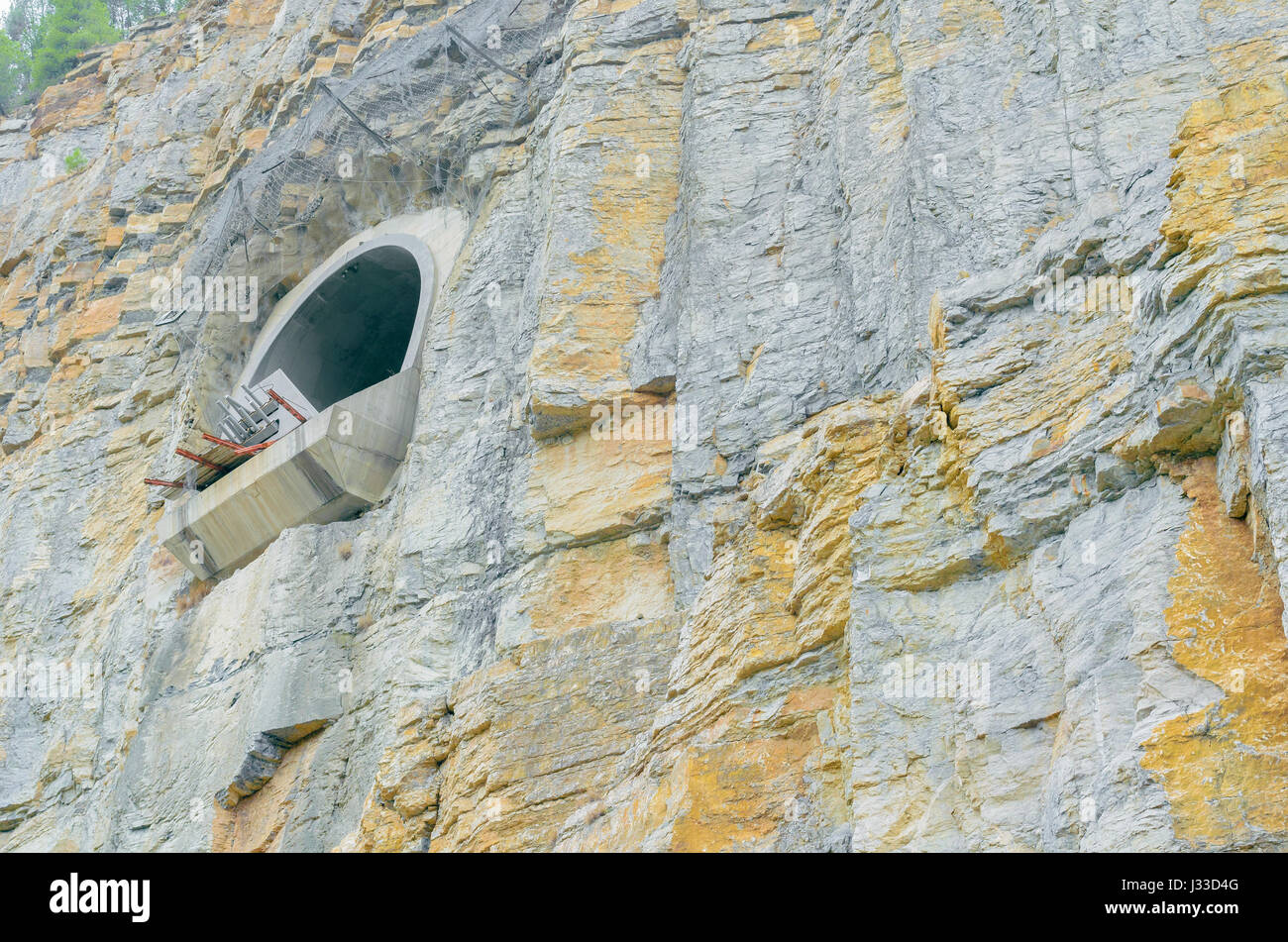 L'espagnol de l'infrastructure. Spilway de grand barrage hydroélectrique. La sortie de l'eau essence off. Mur rocheux de la roche de la montagne. Les arbres avec des feuilles vertes sur le dessus. Banque D'Images