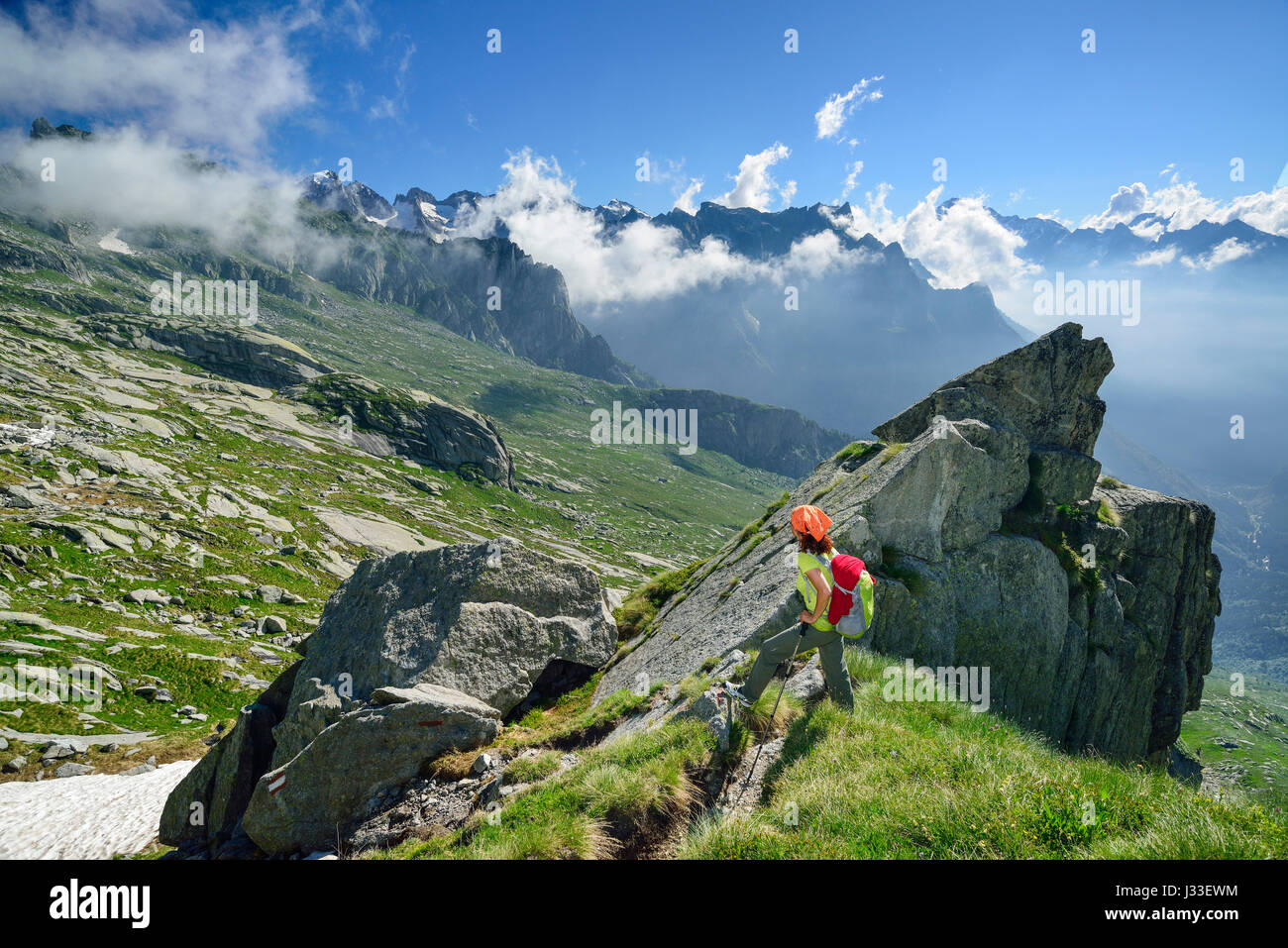 Randonnée femme debout devant rock pinnacle, Sentiero Roma, Bergell, Lombardie, Italie Banque D'Images