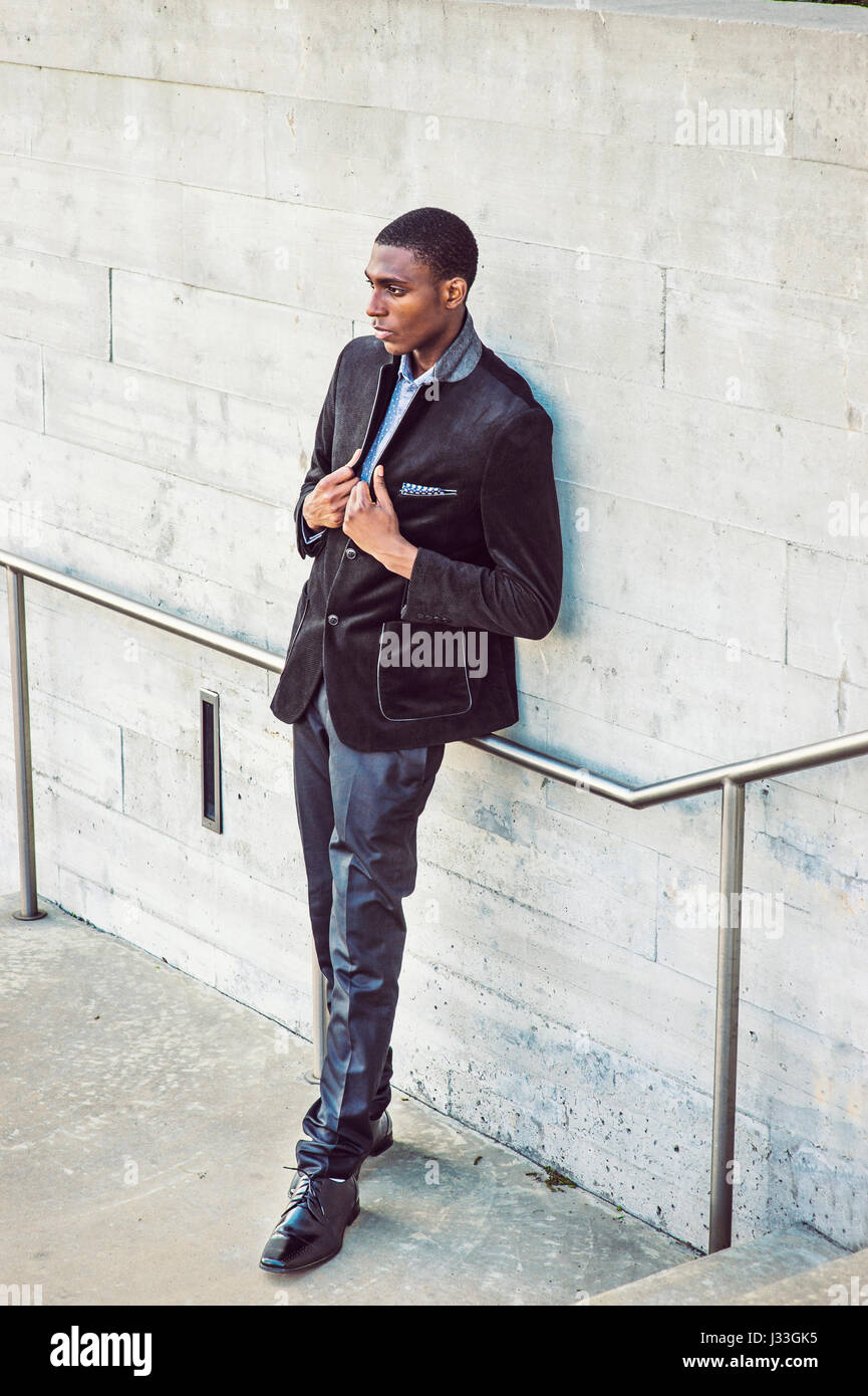 Young African American Man wearing fashionable noir veste, pantalon,  chaussures en cuir, debout contre le mur street à New York, les mains sur  les revers, lookin Photo Stock - Alamy