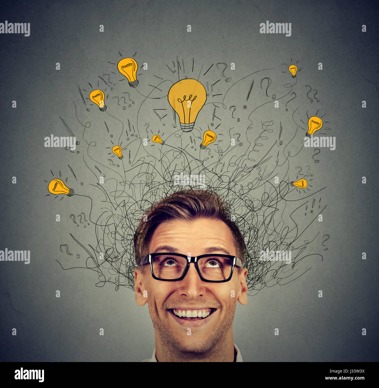 L'homme excité avec beaucoup d'idées au-dessus de la tête des ampoules à haut isolé sur fond de mur gris. La créativité d'Eureka concept Banque D'Images