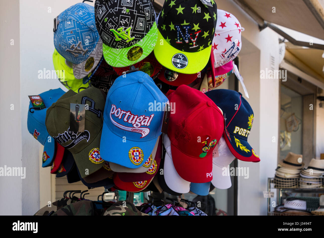 Baseball hats colorés à l'extérieur d'une boutique de souvenirs pour touristes à Tavira Portugal Banque D'Images
