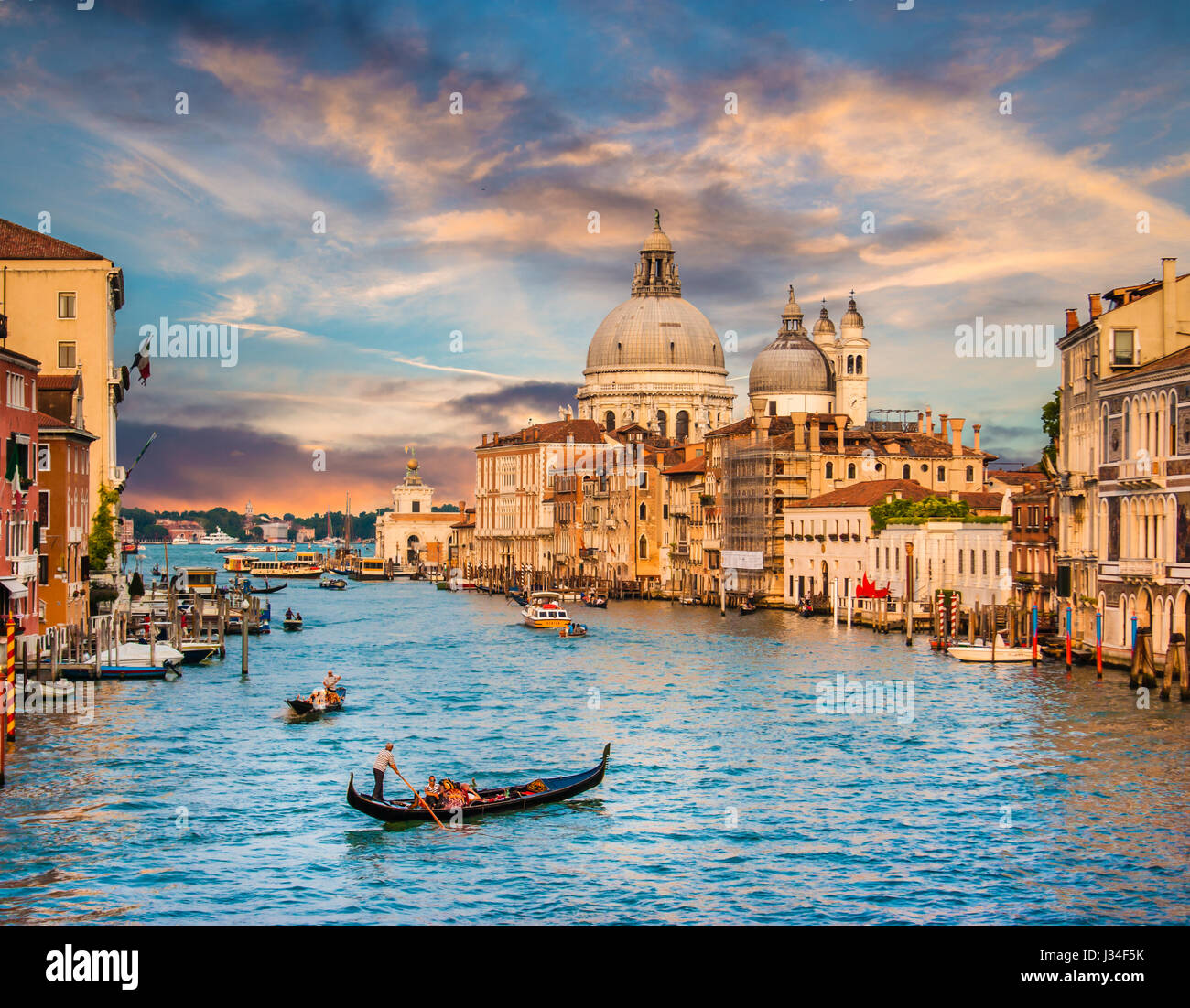 Gondole traditionnelle sur Canal Grande avec la Basilique Santa Maria della Salute au coucher du soleil, Venise, Italie Banque D'Images