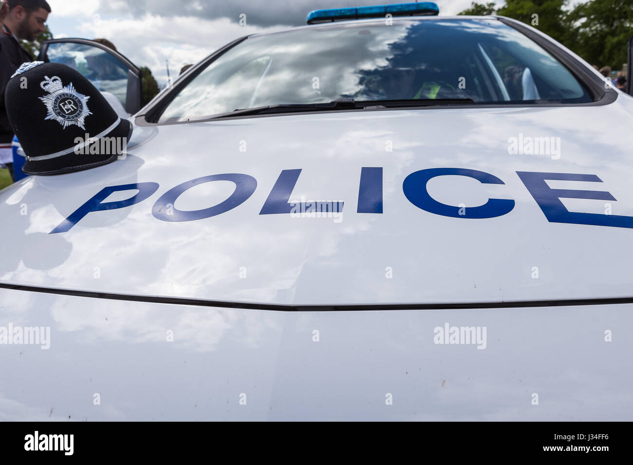 Prise de vue au grand angle de l'avant et le capot d'une voiture de police patrouille marquée avec un casque de police du Bedfordshire assis sur le capot par la porte du conducteur Banque D'Images