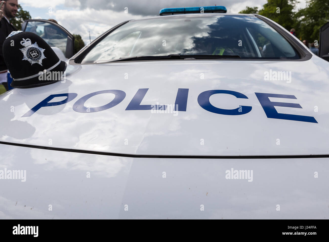 Prise de vue au grand angle de l'avant et le capot d'une voiture de police patrouille marquée avec un casque de police du Bedfordshire assis sur le capot par la porte du conducteur Banque D'Images