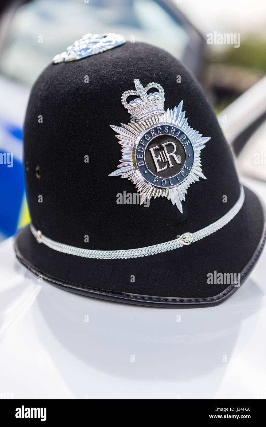 Un gros plan d'un casque de policier Bedfordshire traditionnel assis sur le capot d'une Vauxhall Astra voiture de police avec l'insigne en Crisp focus Banque D'Images