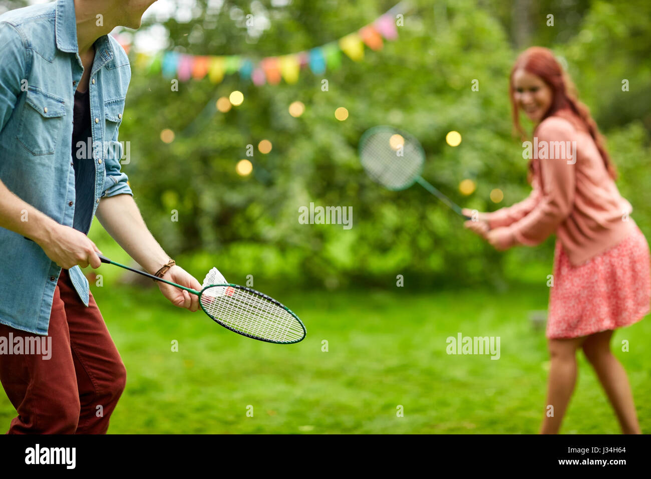 Couple heureux jouer au badminton au jardin d'été Banque D'Images