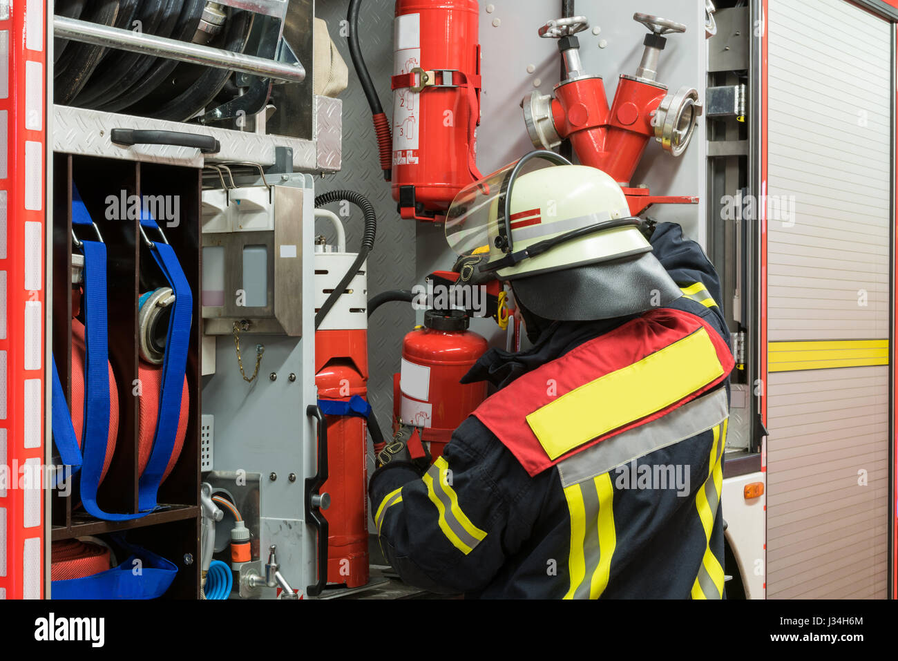 Pompier allemand à extincteur sur le camion de pompiers Banque D'Images