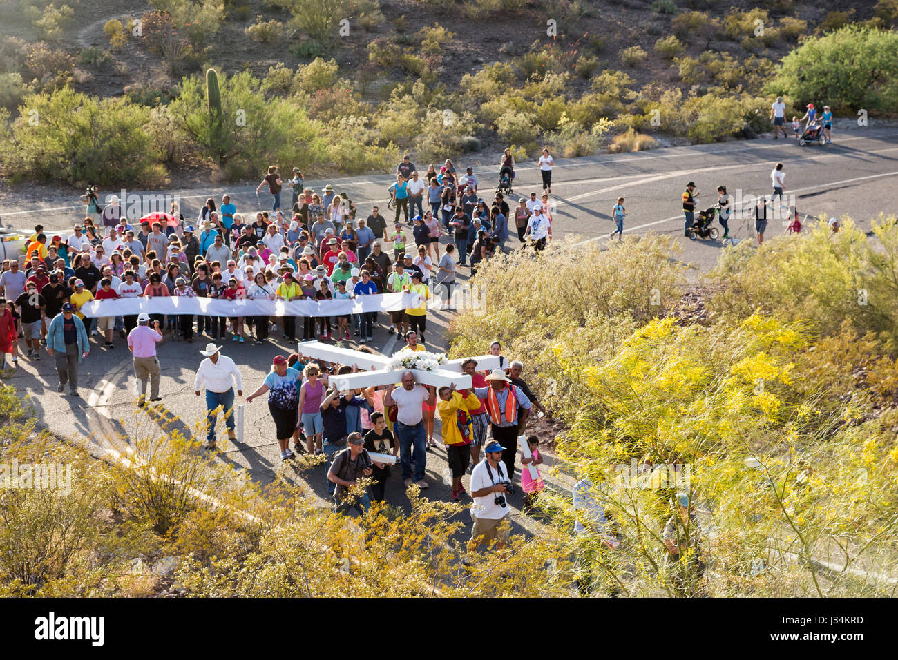 Tucson, Arizona - Les participants à une procession annuelle bon vendredi portent une grande croix de montagne sentinelle. La procession s'arrête pour les stations de la Banque D'Images