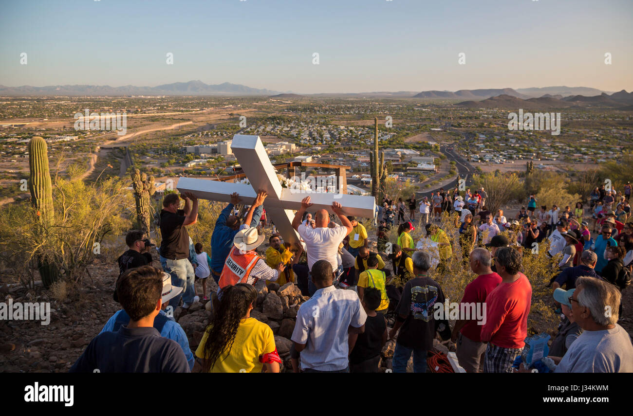 Tucson, Arizona - Les participants à une procession annuelle bon vendredi portent une grande croix de montagne sentinelle. La procession s'arrête pour les stations de la Banque D'Images