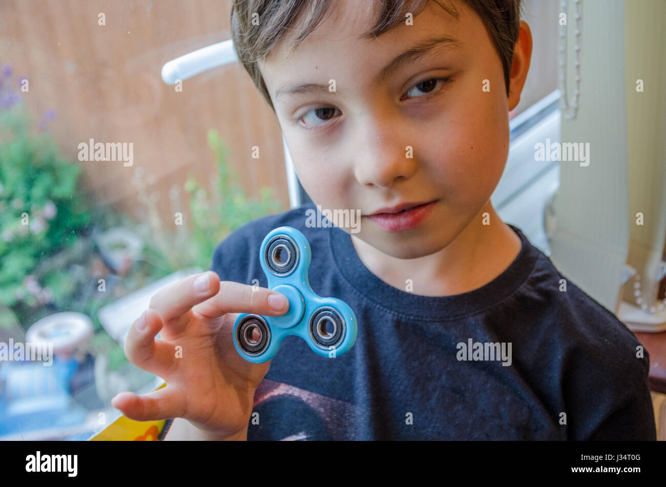 Un jeune garçon évoluant avec un spinner fidget. Banque D'Images