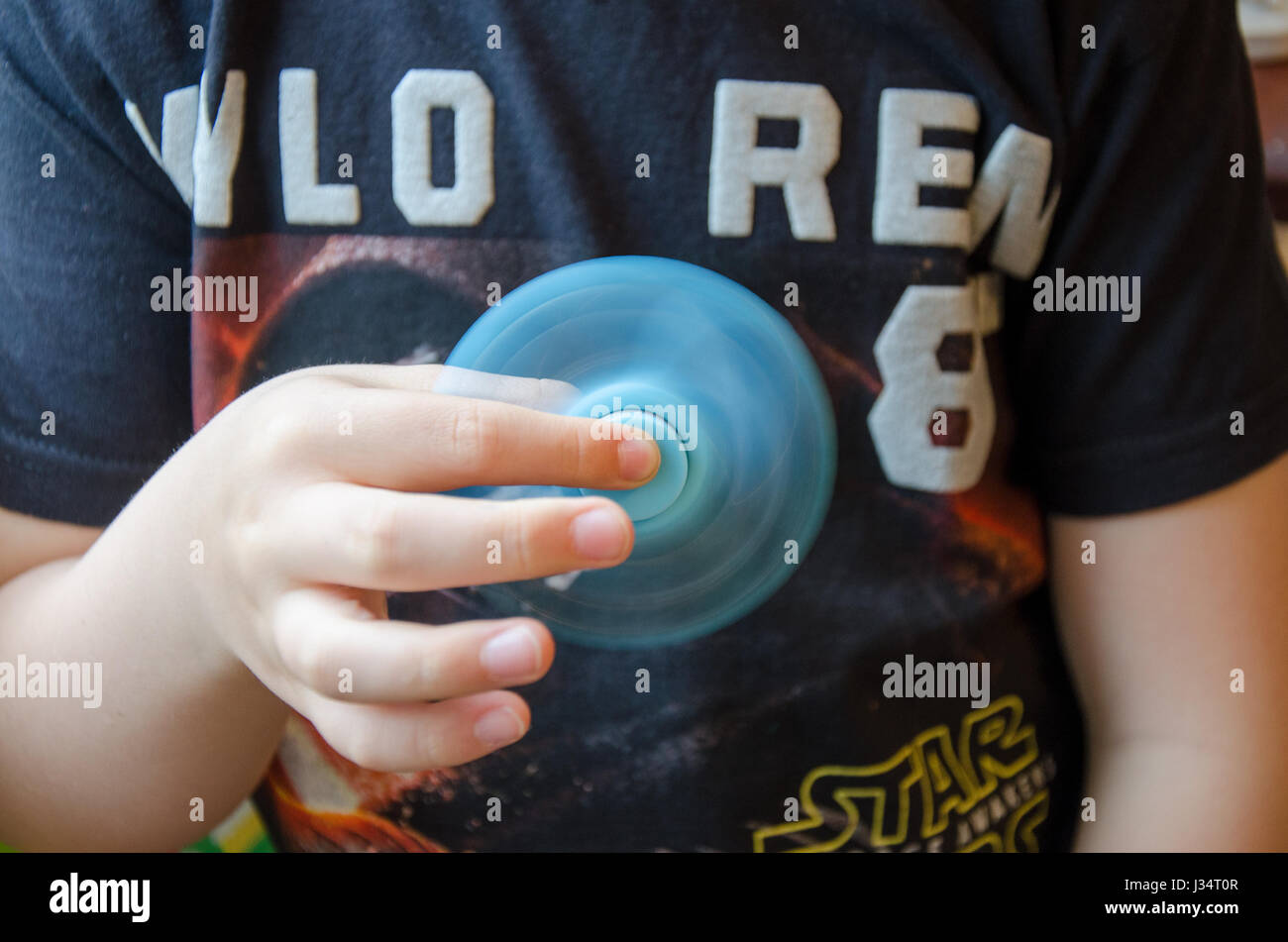 Un jeune garçon évoluant avec un spinner fidget. Banque D'Images