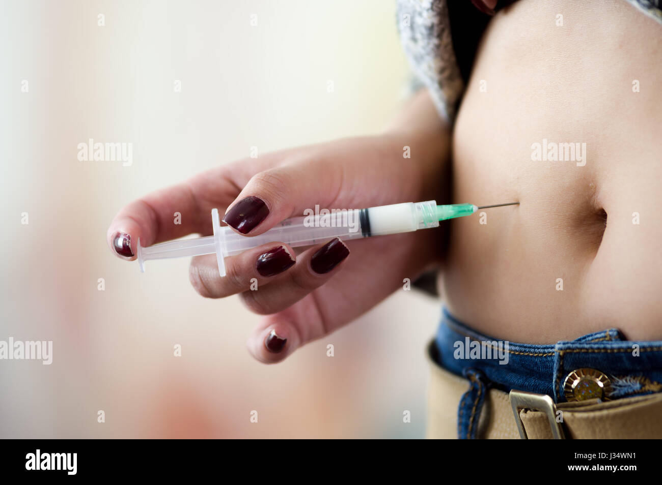 Femme avec une seringue d'injection sous-cutanée de l'abdomen de l'insuline  à son ventre - concept du diabète Photo Stock - Alamy