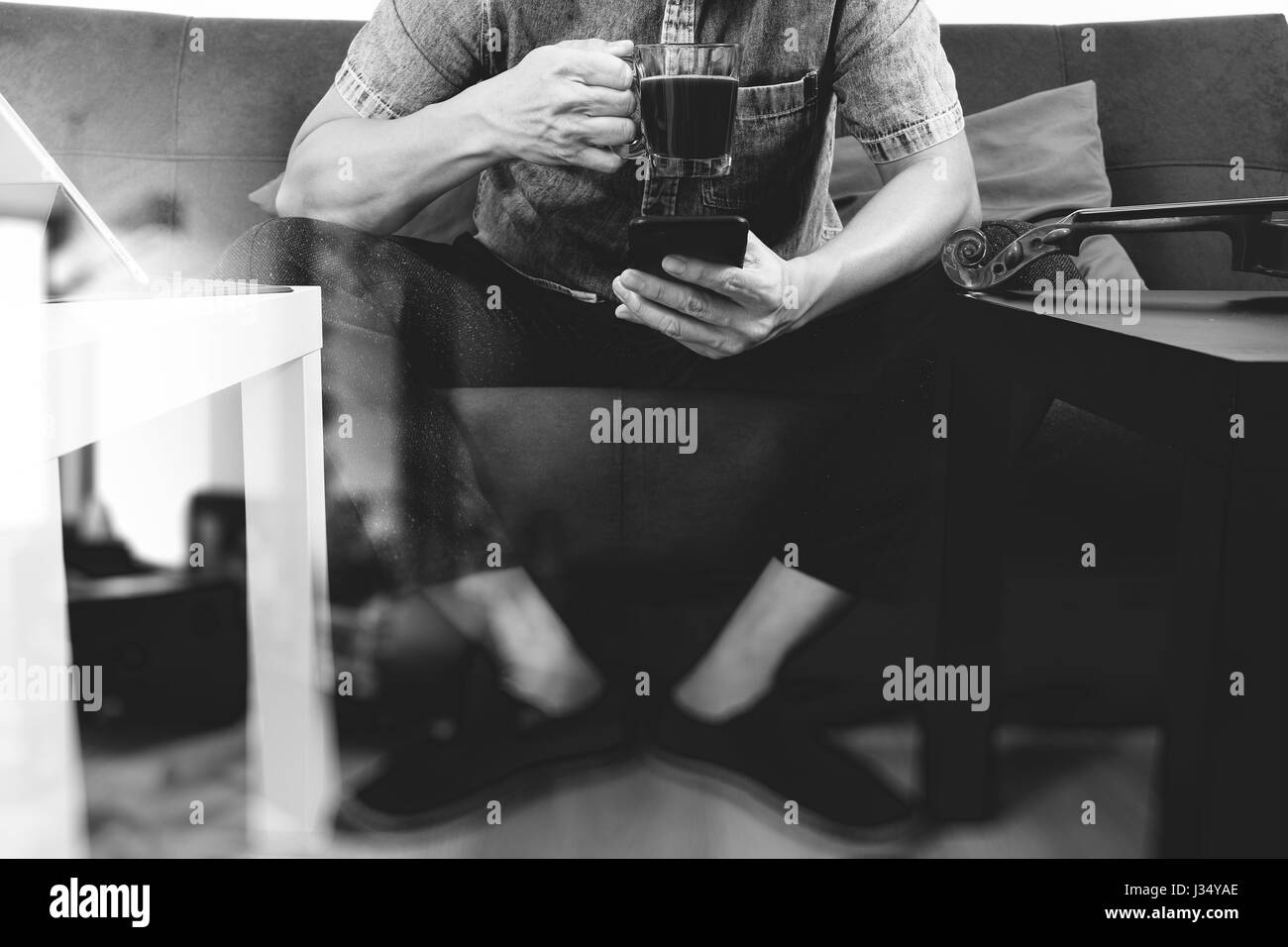 Hipster la main à l'aide de Smart Phone, tablette numérique, clavier d'tasse à café, des paiements en ligne business,sitting on sofa in living room,travailler à domicile concep Banque D'Images