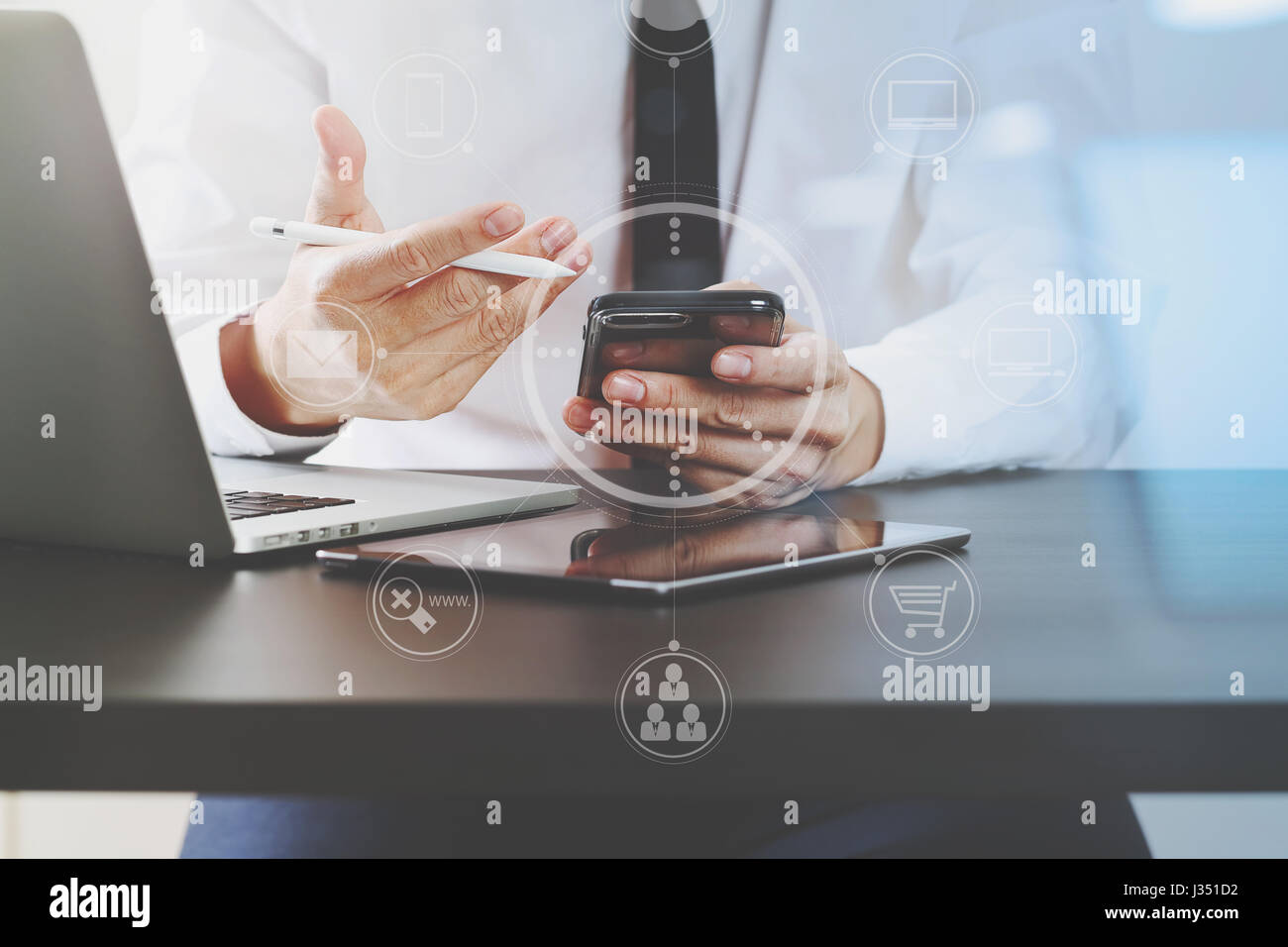 Close up of businessman working with smart phone et tablette numérique et un ordinateur portable sur un bureau en bois dans un bureau moderne avec l'icône virtuelle schéma électrique Banque D'Images