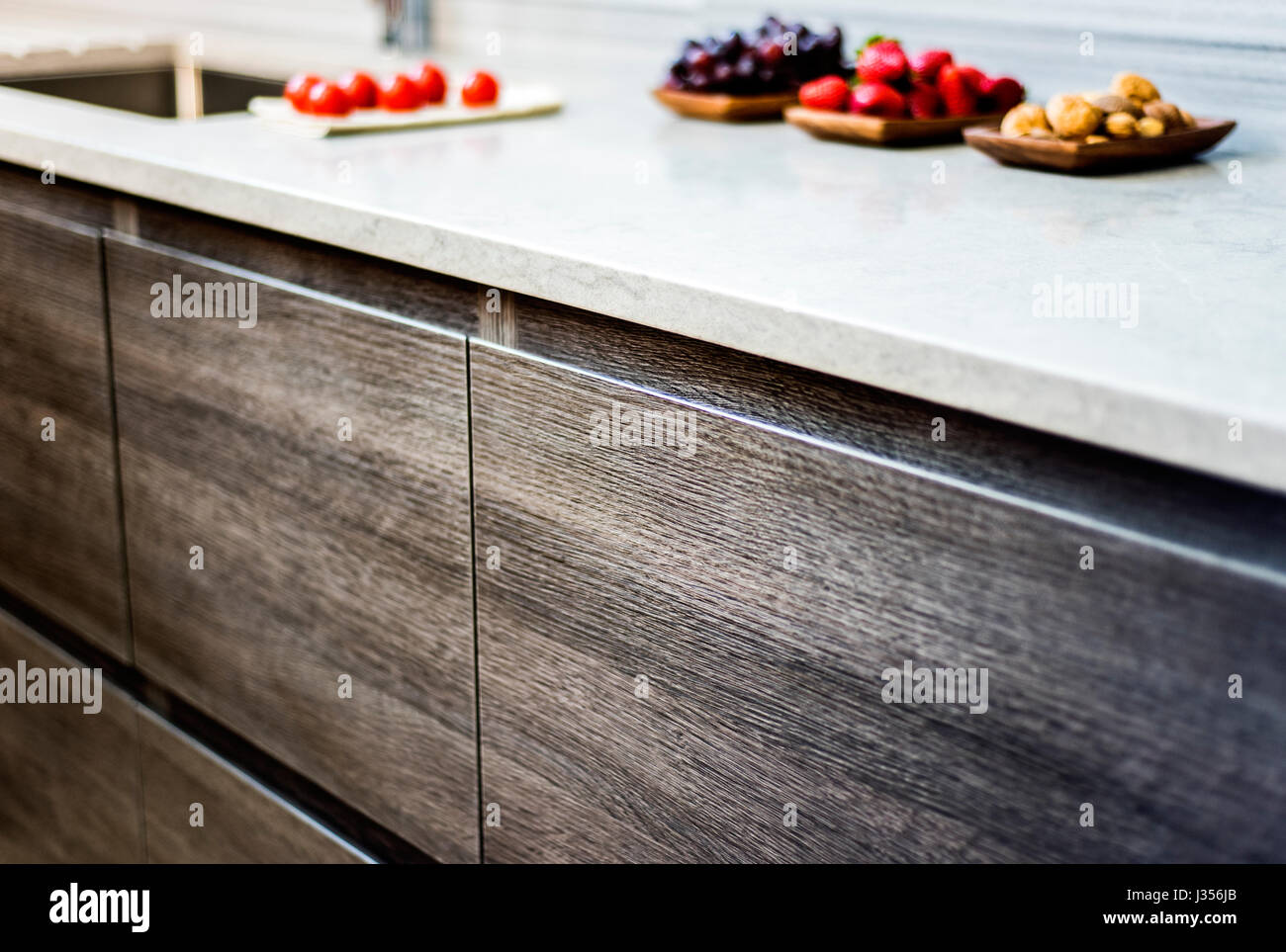 Cuisine moderne avec armoires en bois et plan de travail en quartz Banque D'Images