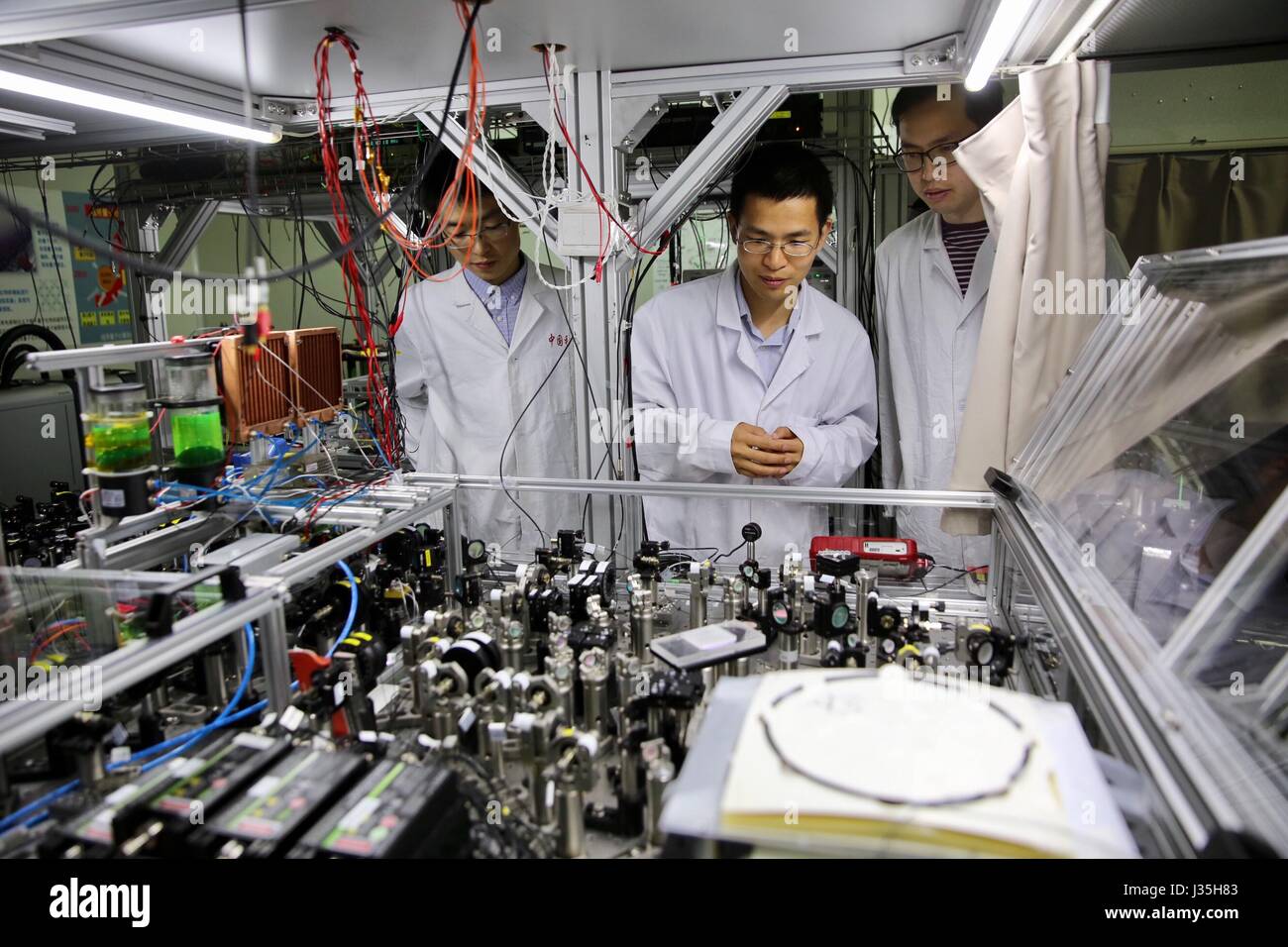 Shanghai, Chine. 3 mai, 2017. Le professeur Lu Chaoyang (C) de l'Université des Sciences et Technologies de Chine vérifie l'état de fonctionnement de l'informatique quantique machine avec ses élèves à un laboratoire à Shanghai, la Chine orientale, le 3 mai 2017. Les scientifiques chinois ont construit le premier quantum computing machine qui va bien au-delà de la classique précoce -- ou conventionnelle -- ordinateurs, ouvrant la voie à la réalisation ultime de l'informatique quantique. Credit : Jin Liwang/Xinhua/Alamy Live News Banque D'Images