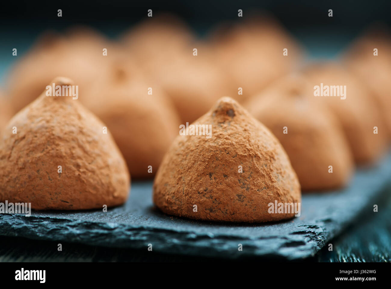 Truffe au chocolat noir sur le conseil de pierre et sur une table Banque D'Images