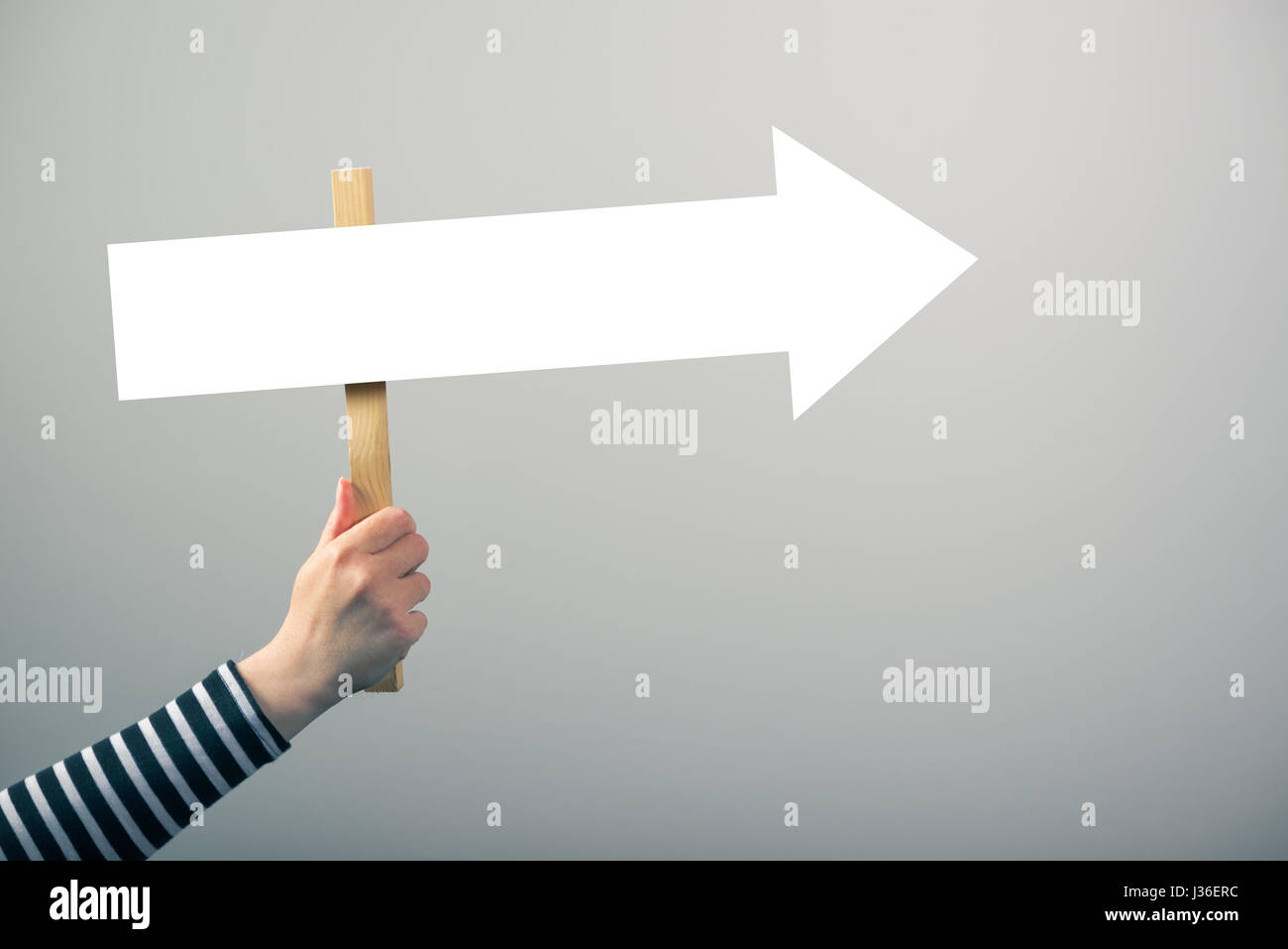Femme tenant la flèche de direction directeurs signent en main, concept d'orientation et de la prise de décisions Banque D'Images