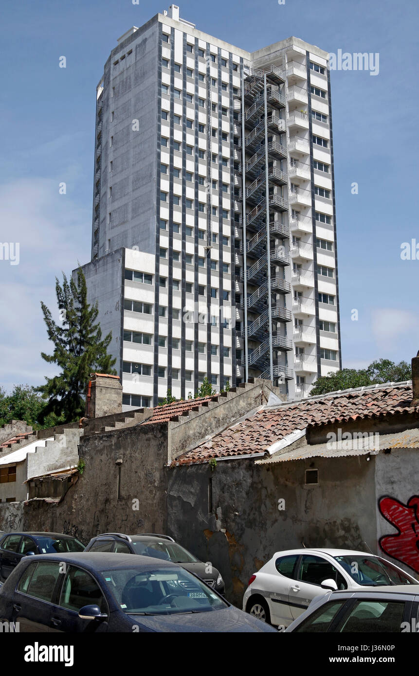 Bloc de bureau laid surplombe un petit groupe de 20 cottages construits accidents c1890, maintenant abandonné et menacé de démolition, dans Campodile, Lisbonne. Banque D'Images