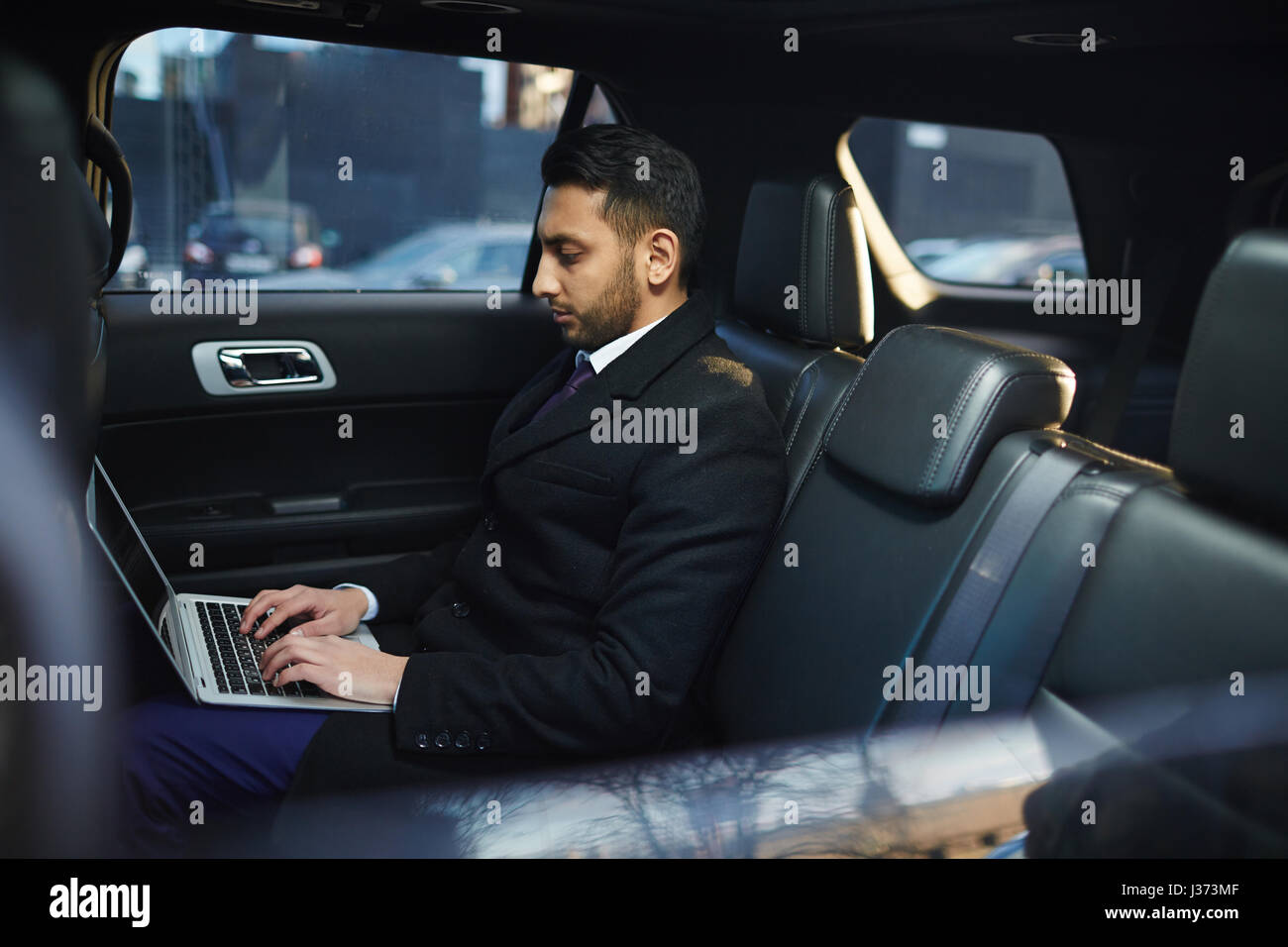 Successful Businessman using Laptop in Car Banque D'Images