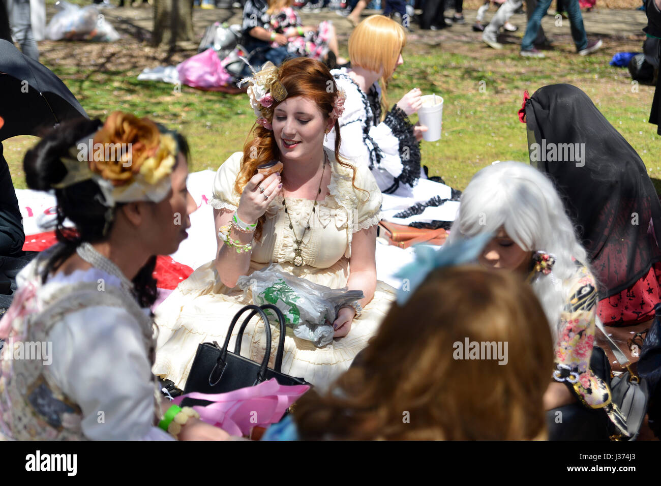 Vêtus de la mode japonaise des membres de Frilladelphia s'asseoir sur la pelouse sous les arbres de Sakura comme des milliers profitez d'éléments emblématiques de la culture japonaise Banque D'Images