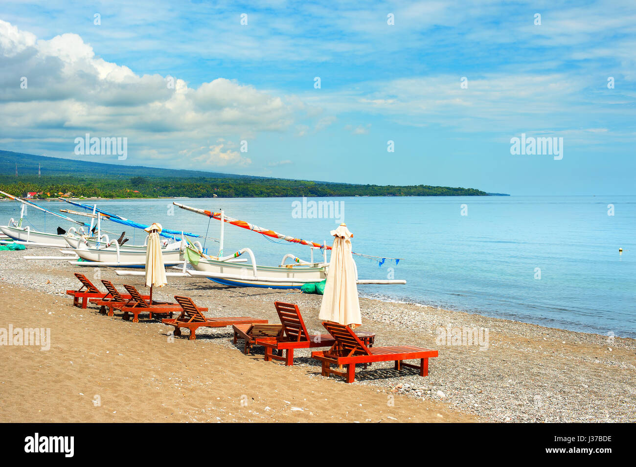 Chaise longue et bateaux de pêche sur la plage. Amed, Bali, Indonésie Banque D'Images