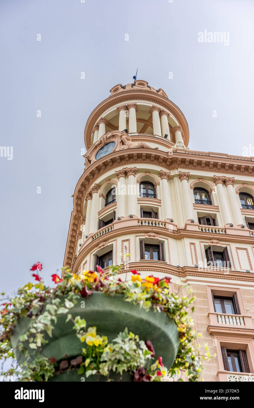 Compte tenu de l'échelle de la rue Vitalicio Construire tour et avant-plan flou décoration florale de Plaza de Callao Square. Situé dans la Gran Via, Madrid Banque D'Images