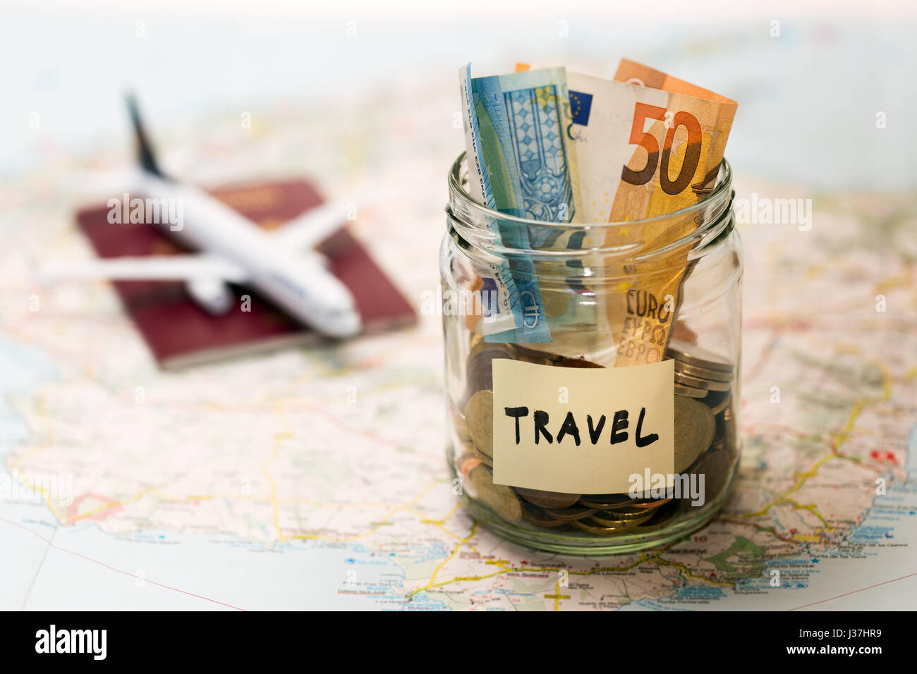 Budget voyage, concept d'épargne de l'argent dans un bocal en verre sur une carte Banque D'Images
