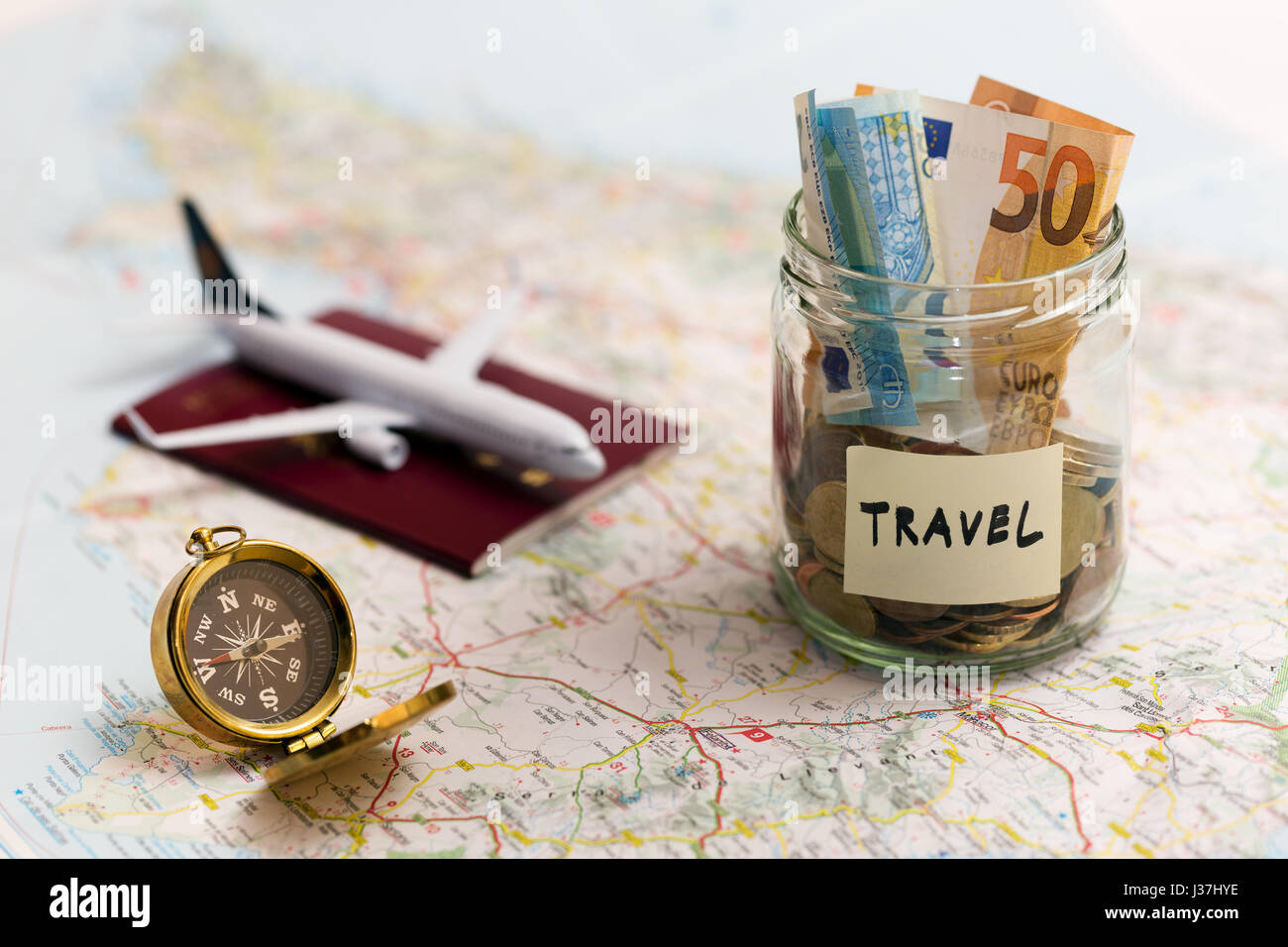 Travel Concept - économies d'argent, boussole et de passeport sur une carte Banque D'Images