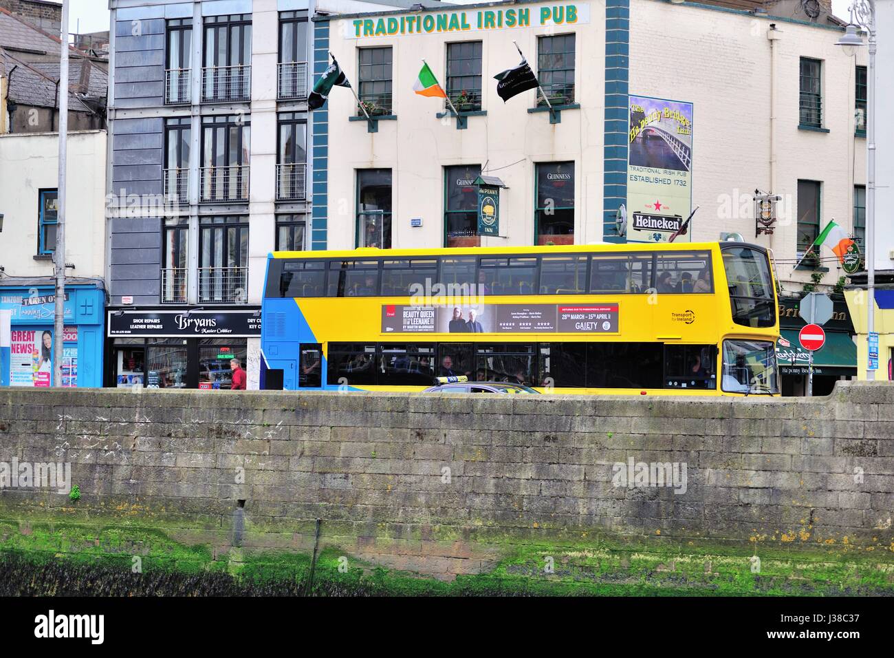 Un bus à impériale de la ville en passant le long de la rivière Liffey à Dublin, Irlande. Banque D'Images