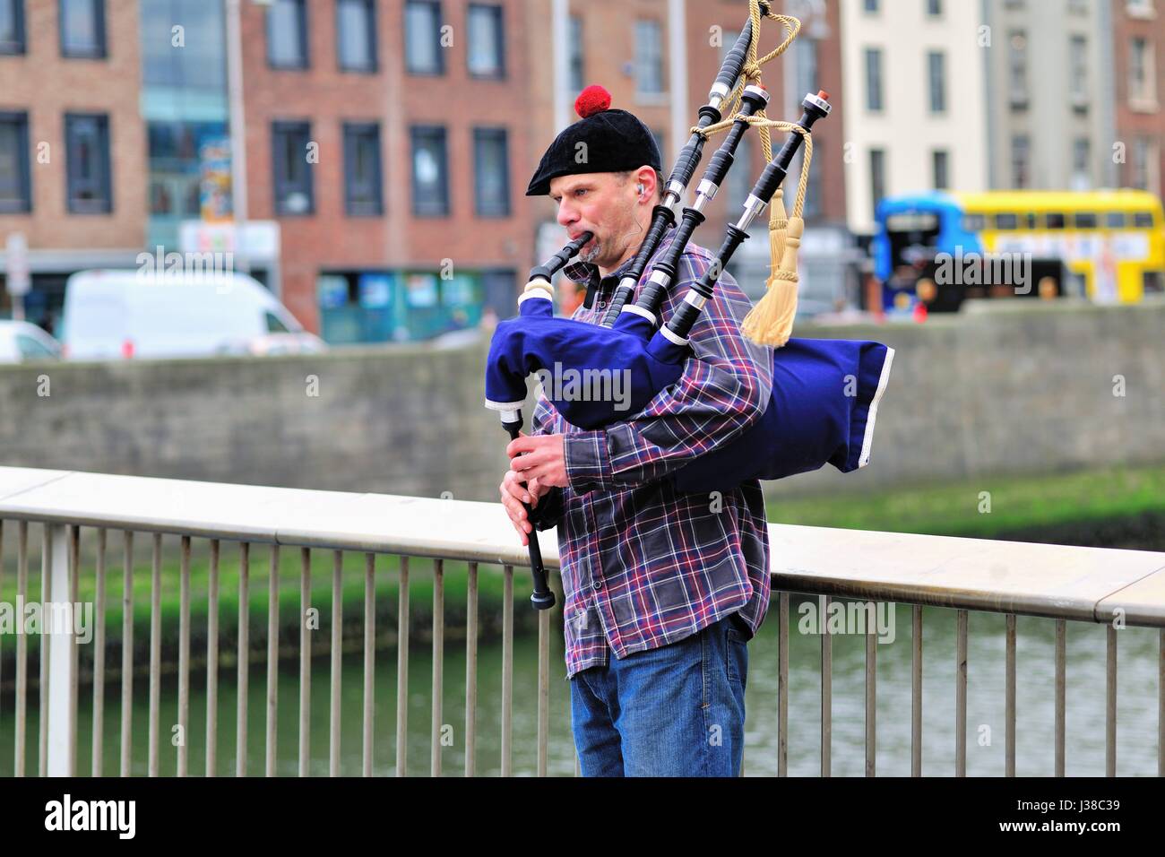 Un Piper irlandais jouant le sac tuyaux sur le Ha'penny Bridge sur la rivière Liffey à Dublin, Irlande. Banque D'Images