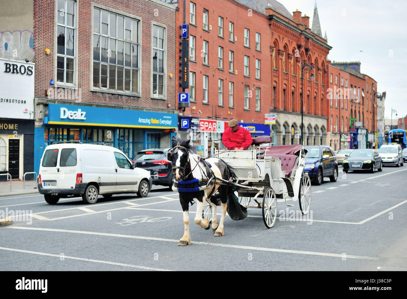 Une balade en calèche à travers la négociation de la circulation sur une rue du centre-ville de Dublin, en Irlande. Banque D'Images