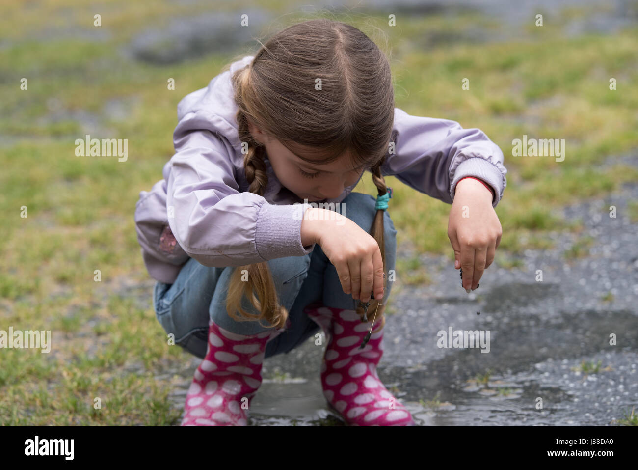 Petite fille jouant dans la pluie Banque D'Images