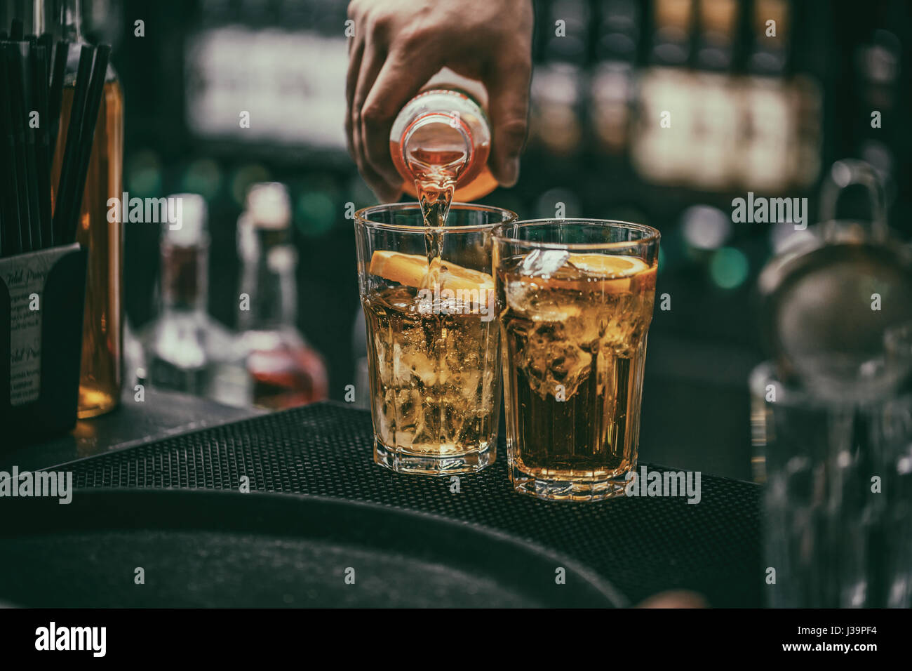 Barman verse de boisson alcoolisée en verre à cocktail Banque D'Images