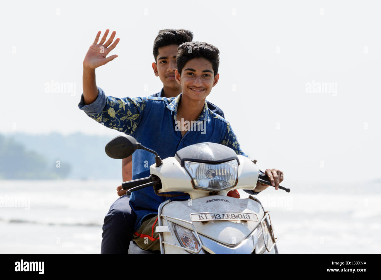 Deux jeunes garçons rouler une moto le long menMuzhappilangad beach, Kerala's drive-in seulement plage, Kannur(Cannanore), Kerala, Inde du Sud, l'Asie du Sud. Banque D'Images