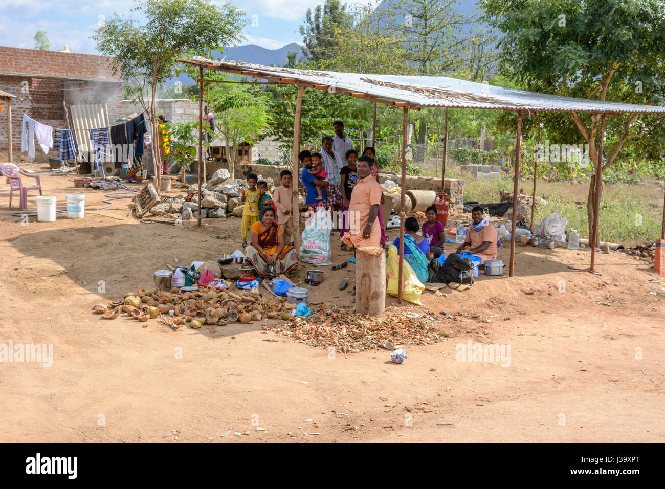 Un Tamoul tribal family s'asseoir à l'ombre à leur domicile en milieu rural dans les plaines agricoles du Tamil Nadu, Inde du Sud, en Asie du Sud Banque D'Images