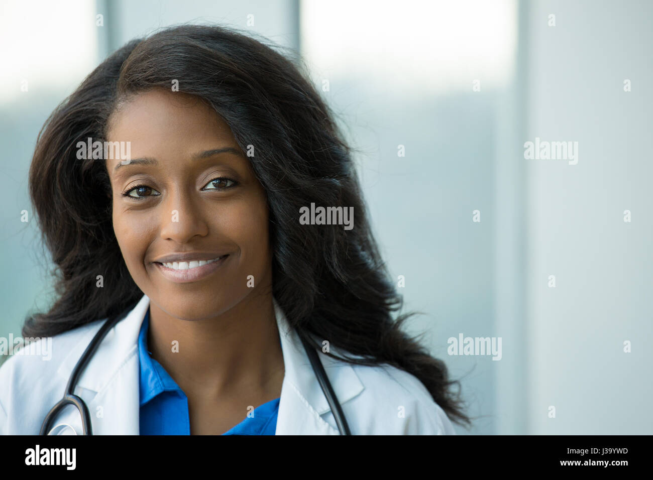 Closeup portrait of smiling confident female amical, professionnel de santé avec manteau de laboratoire, stéthoscope, les bras croisés. Hôpital clinique isolé retour Banque D'Images