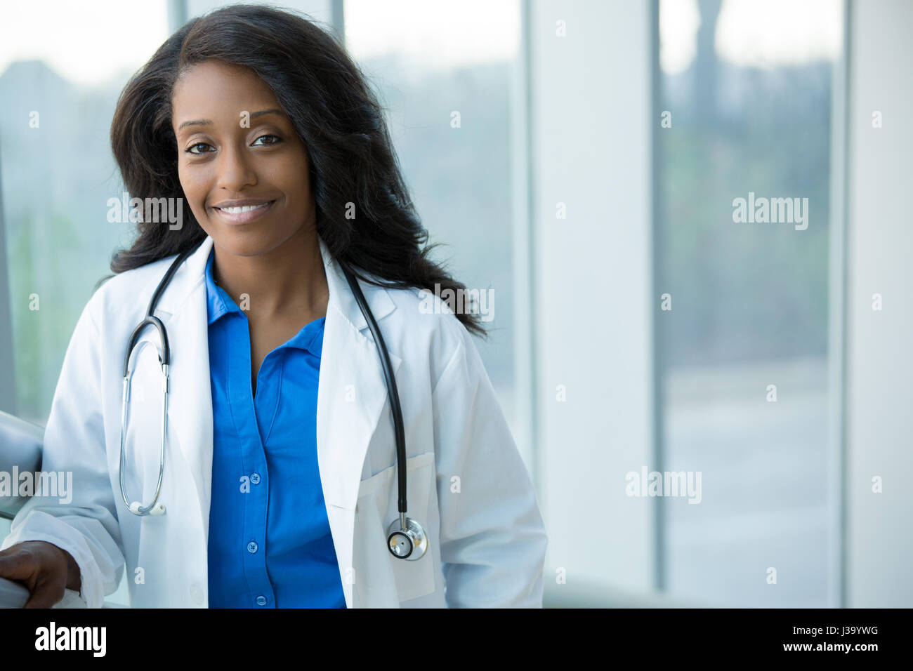 Closeup portrait of smiling confident female amical, professionnel de santé avec manteau de laboratoire, stéthoscope, les bras croisés. Hôpital clinique isolé retour Banque D'Images