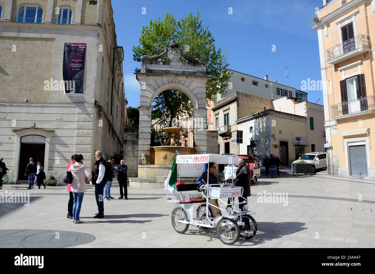 Un guide touristique dans un vélo à quatre roues en attente de clients d'une piazza antiques ville de Matera Basilicate Italie Banque D'Images