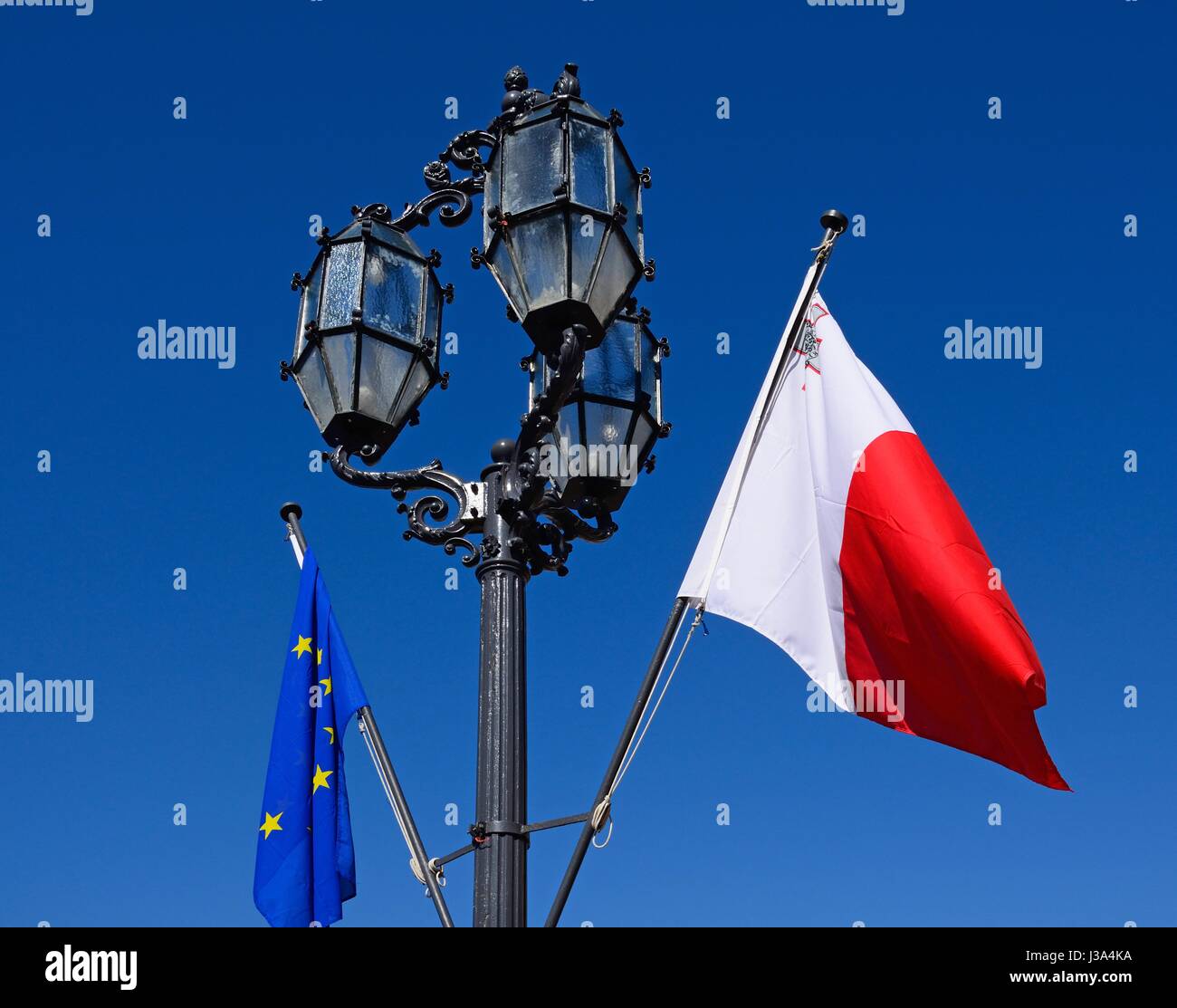 Lampadaire en fer forgé avec le pavillon maltais et drapeau de l'Union européenne dans la région de Castille Square, La Valette, Malte, Europe. Banque D'Images