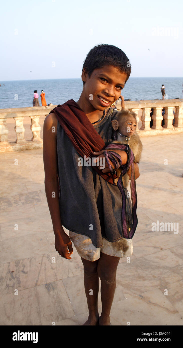 Un garçon avec son singe sur le front de mer d'Azur, France Banque D'Images