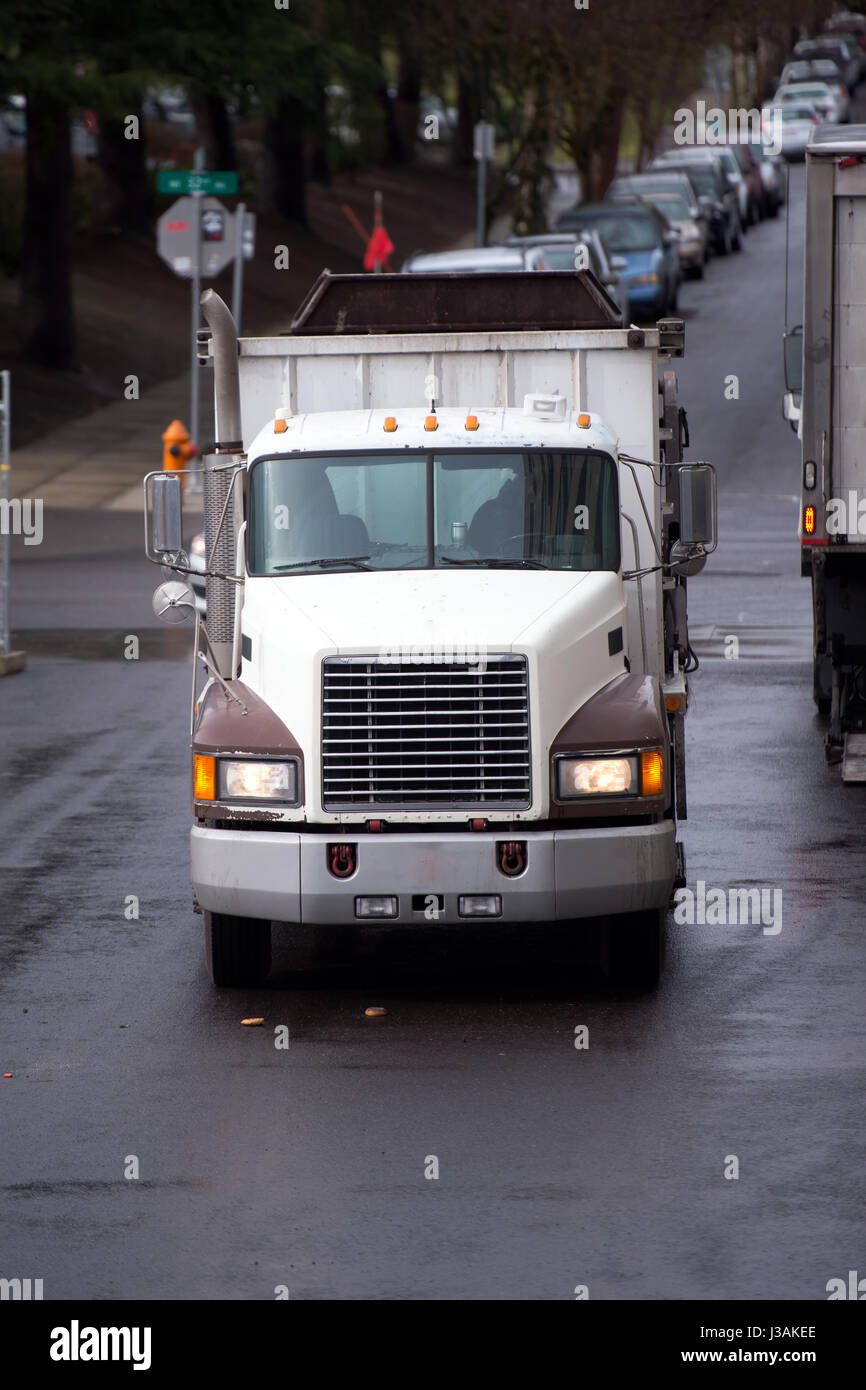 Un vieux camion semi avec un camion-benne pour le transport de matériaux de construction sur les chantiers de construction, des promenades le long de la rue de la ville avec des voitures en stationnement Banque D'Images