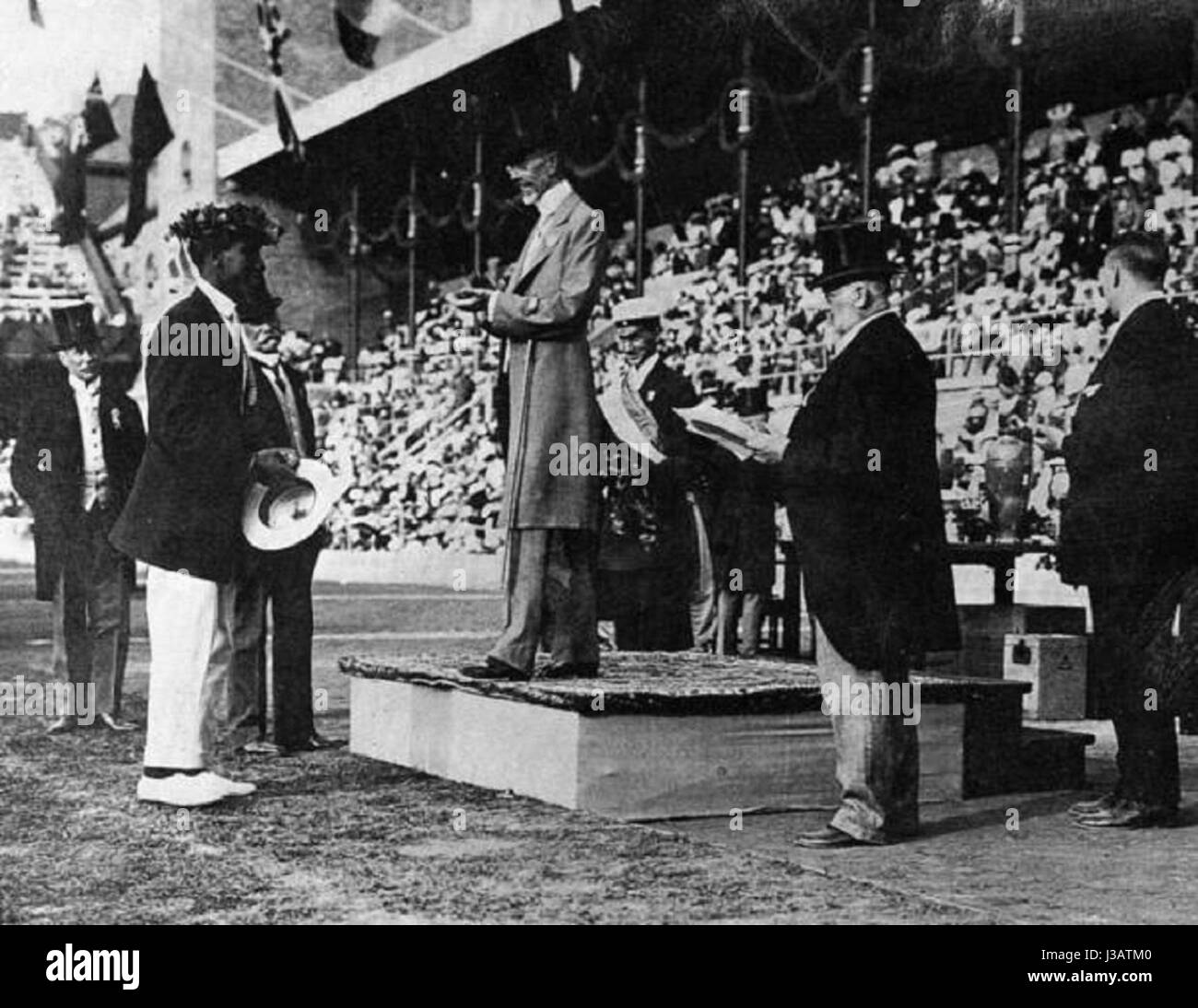 Duke Kahanamoku, un nageur hawaïen, a remporté la médaille d'or olympique en 1912 à Stockholm, en Suède. L'image représente Kahanamoku recevant sa médaille des mains du roi Gustave de Suède, un moment historique dans l'histoire olympique et de la natation. Banque D'Images