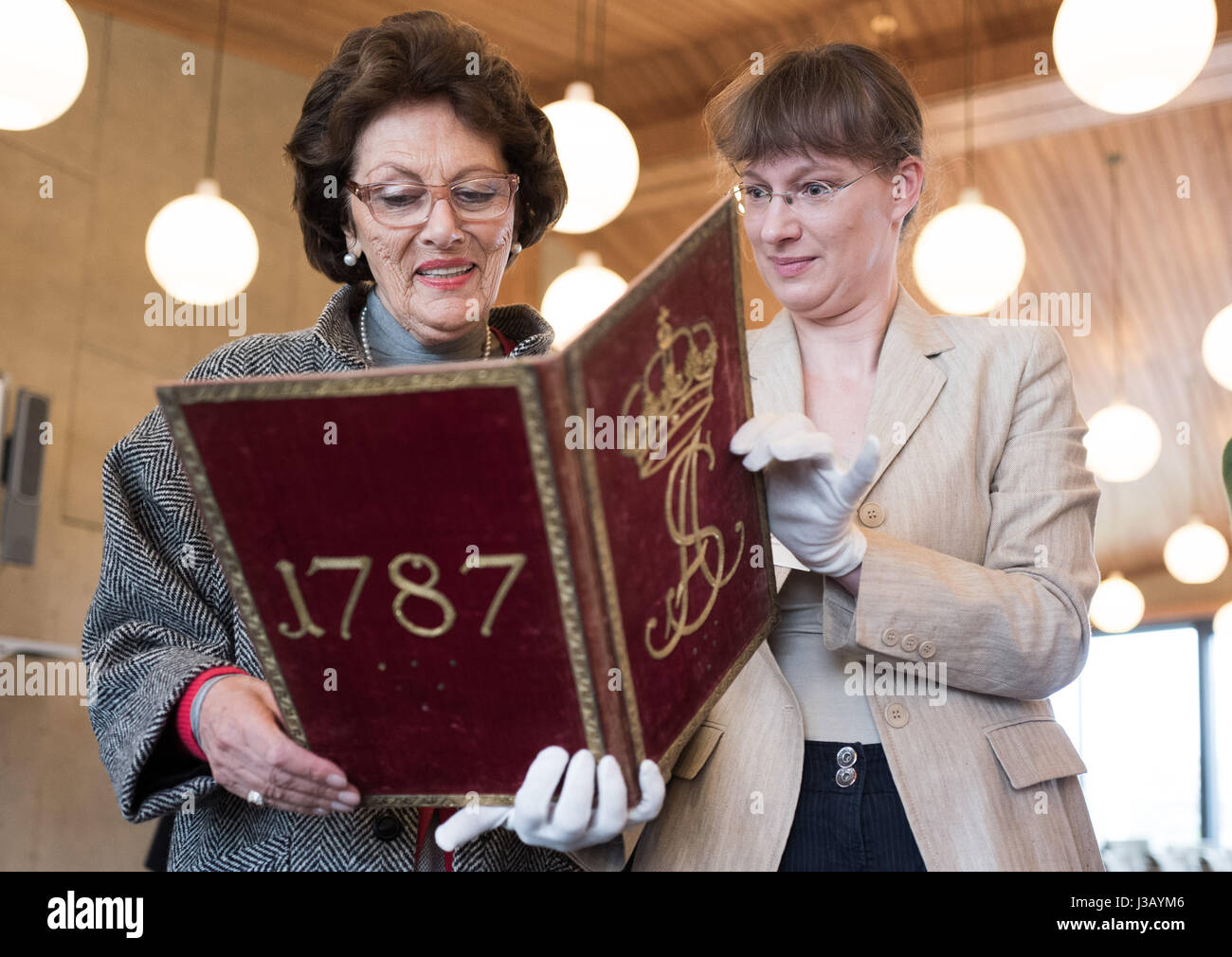 Maja Oetker (L), épouse de l'industriel, est montré l'un des volumes de la bibliothèque 'Princess' par le conseiller Silke La à Berlin, Allemagne, 4 mai 2017. Elles sont l'hommage écritures pour Sophie Albertine. Le volume 4500 strong collection de Sophie Dorothea de Hanovre, Reine de Prusse (1712-1786), Luise Preußen Ulrike, Reine de Suède (1720-1782) et Sophie Albertine, Princesse de Suède (1753-1829) a été acheté par la Fondation Palais et jardins prussiens, avec l'aide de cinq autres fondations et 120 personnes privées. Photo : Jörg Carstensen/dpa Banque D'Images