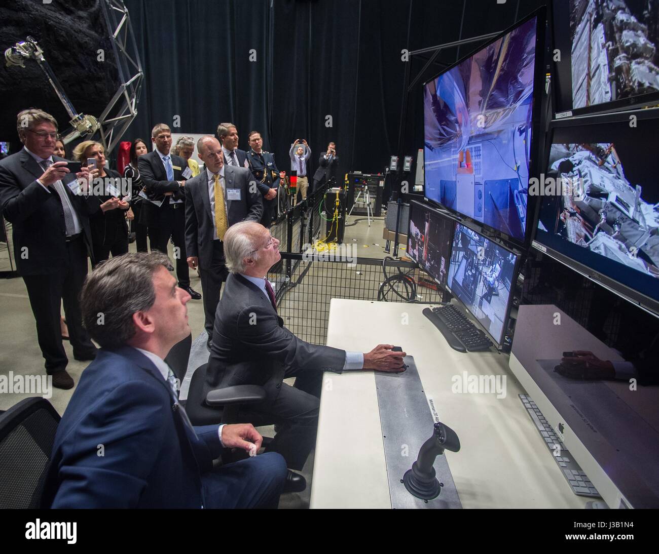 Sa Majesté le Roi de Suède Le Roi Carl XVI Gustaf, centre, tente sa chance à l'exploitation d'un bras robotique à distance sous l'œil attentif de Benjamin Reed, directeur de division adjoint de la Division des projets de service par satellite au cours d'une visite d'une délégation suédoise au Goddard Space Flight Center 3 mai 2017 à Greenbelt, Maryland. Banque D'Images