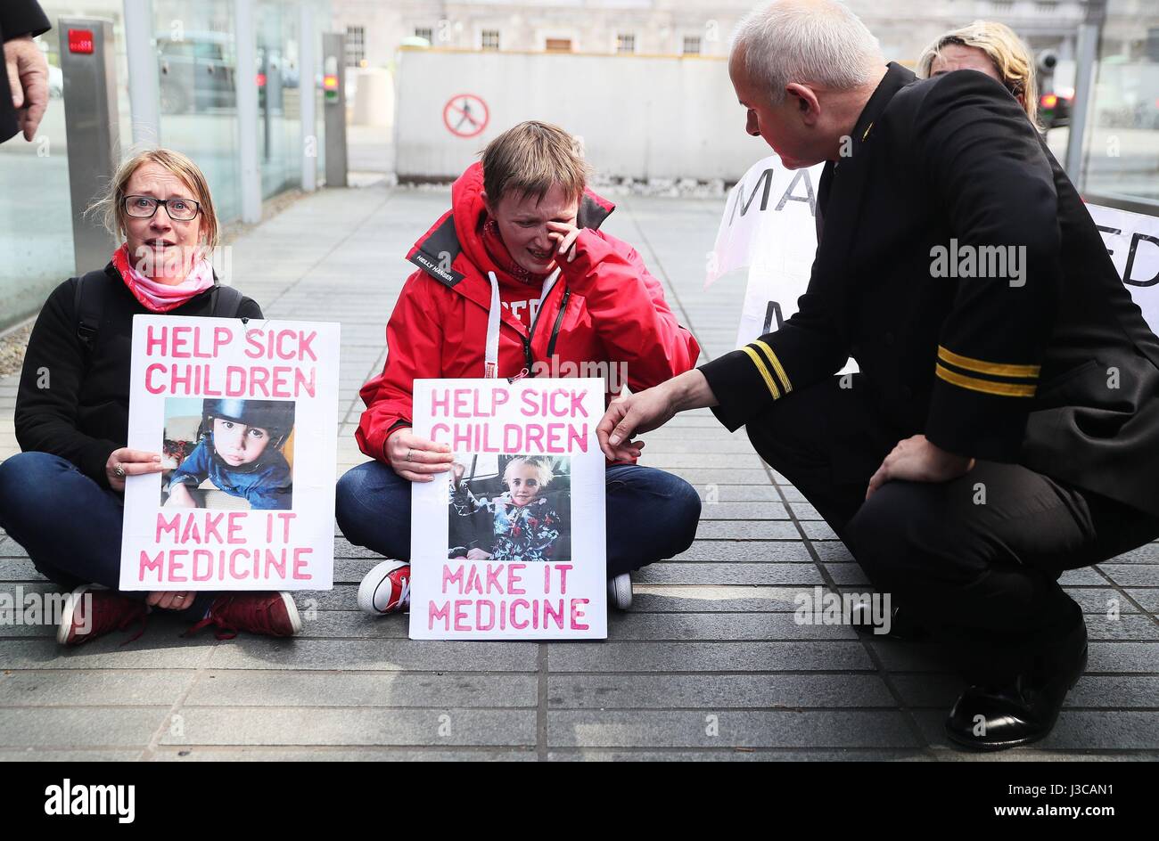Les militants pour la légalisation du cannabis médicinal Vera Twomey (centre) et Sarah Mahoney phase a s'asseoir à l'intérieur de la protestation portes de Leinster House, Dublin. Banque D'Images