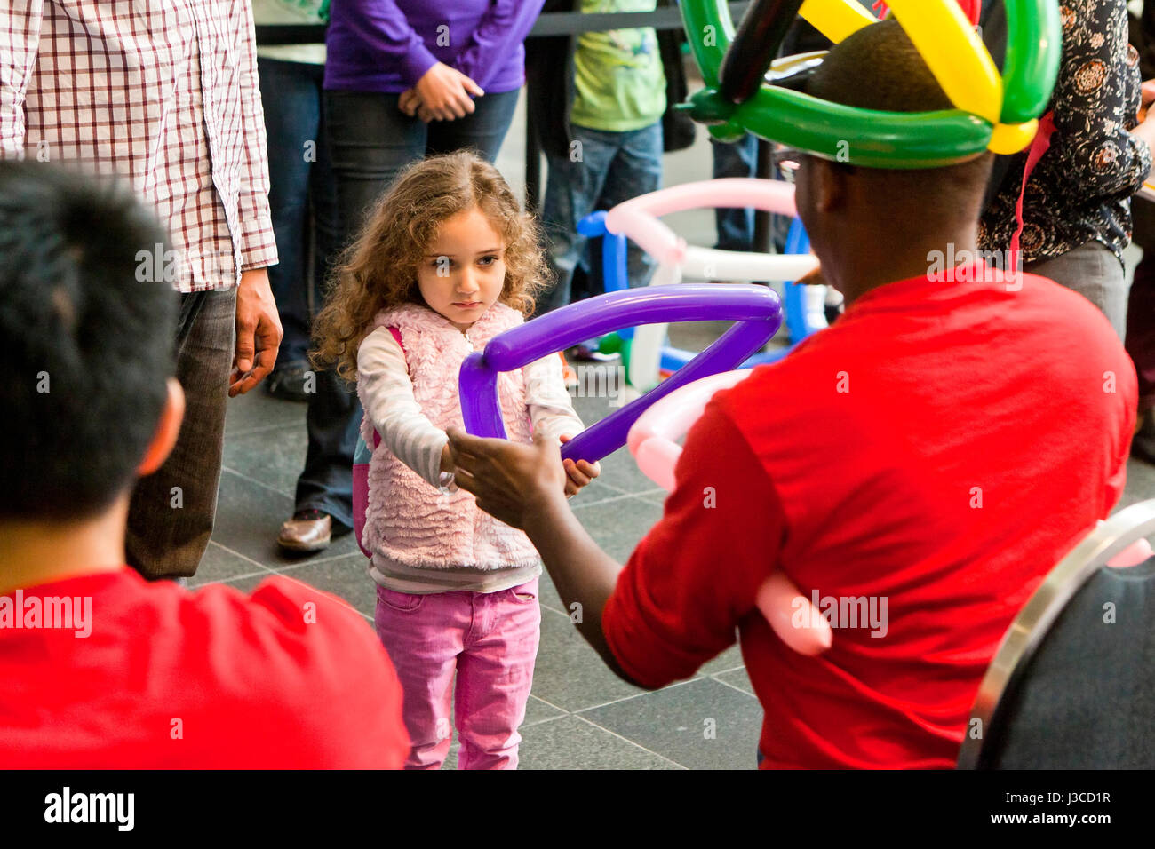 Petite fille (5, 6 ans) l'obtention d'un caractère pris à un ballon pour l'événement - USA Banque D'Images