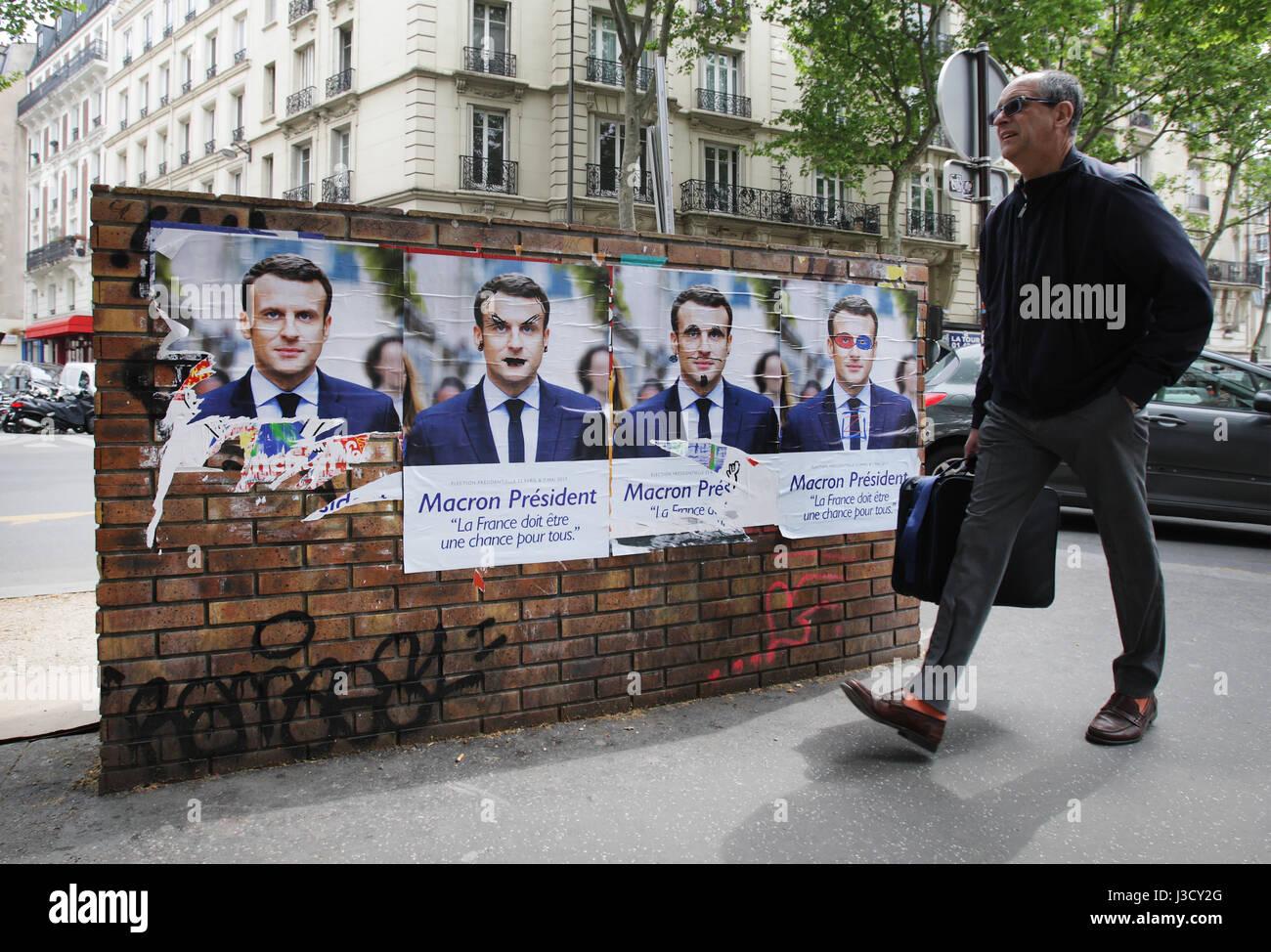 Un homme marche en campagne électorale, des affiches de l'élection présidentielle française pour le candidat en marche ! Circulation Emmanuel Macron à Paris,France le Mai Banque D'Images