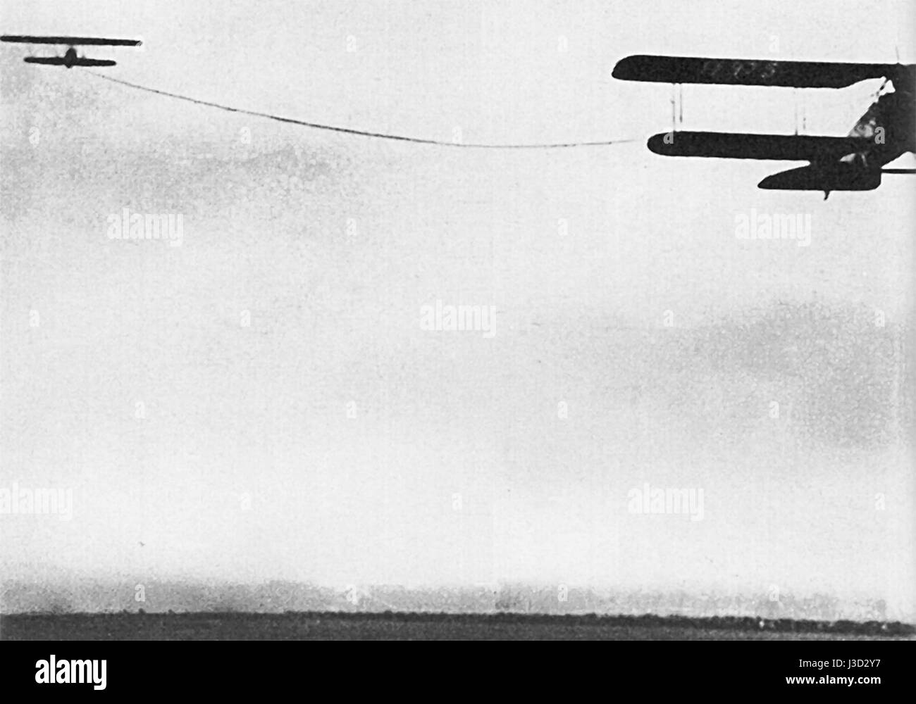 Cette image capture le premier événement public de remorquage d'avion le 18 avril 1927. Le vol historique marque un moment important dans l'histoire de l'aviation, mettant en valeur les premières techniques d'aviation et l'intérêt du public pour le vol. Banque D'Images