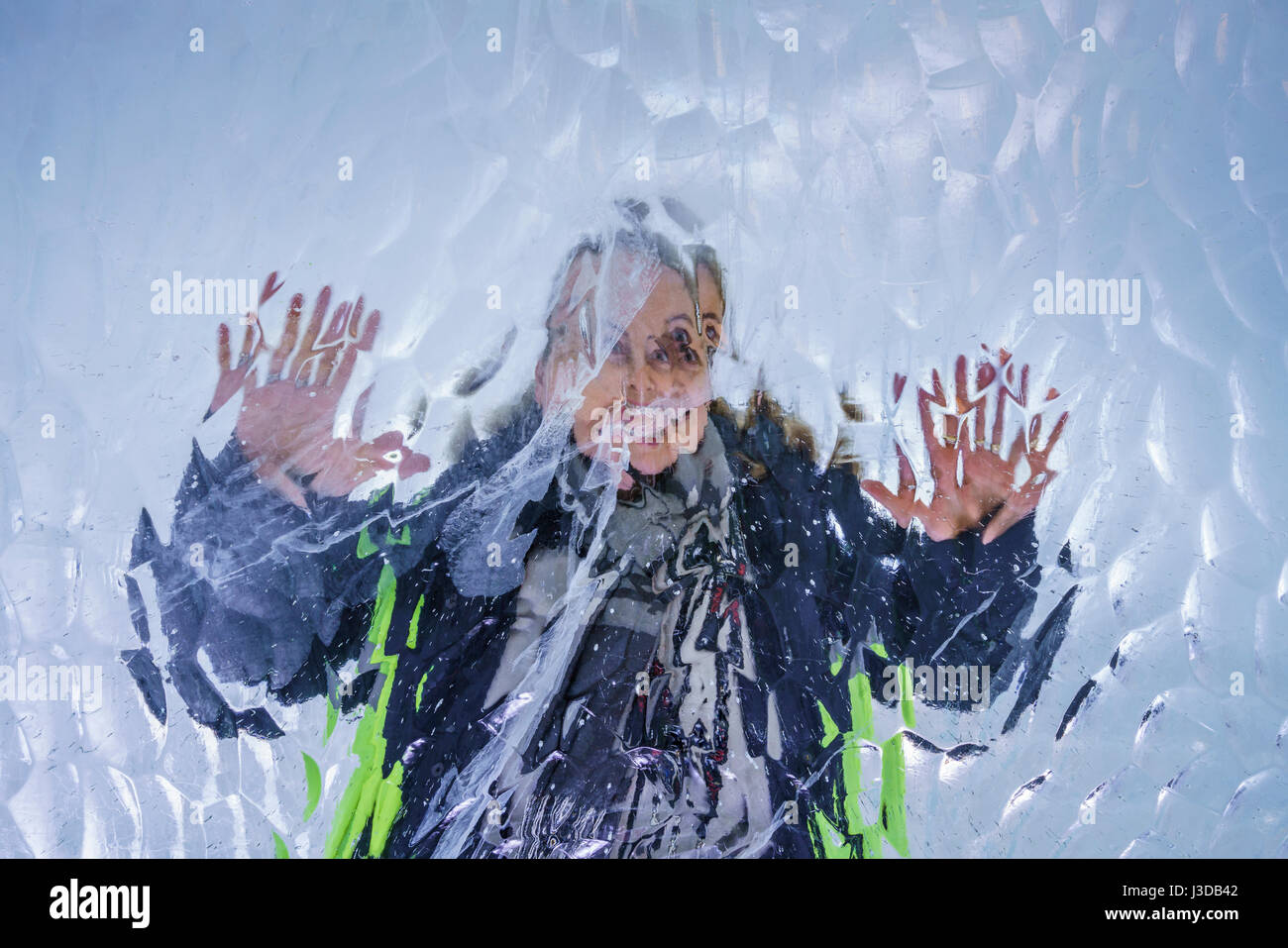 Femme derrière un mur de glace Banque D'Images